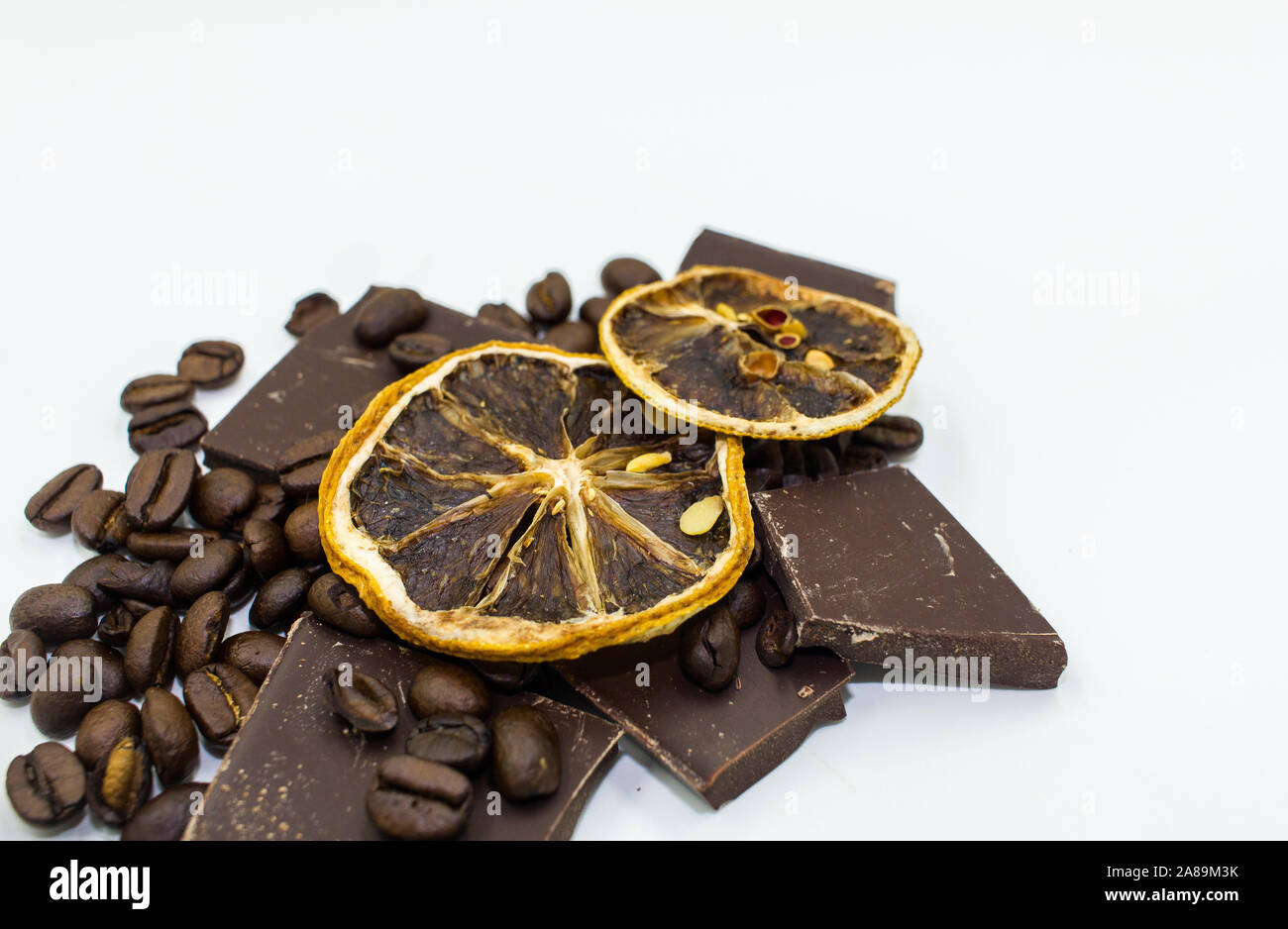 Essiccato fettine di arancia sulla sommità del cioccolato fondente i pezzi e i chicchi di caffè - Sfondo bianco Foto Stock