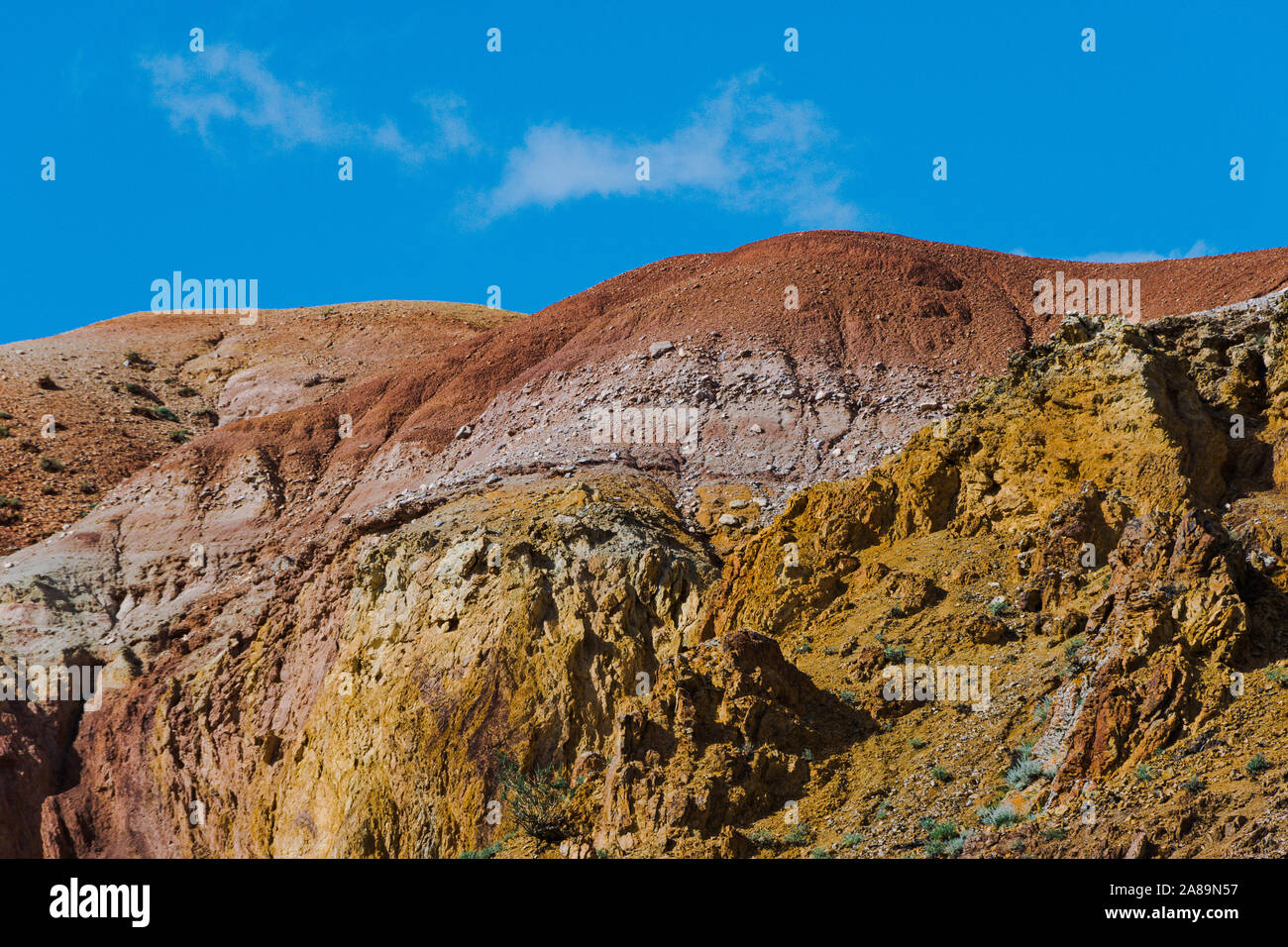 Colline colorate, strisce di colori diversi sul pendio del canyon. Terra asciutta a causa di mancanza di acqua. Siccità nel deserto. Erosione del suolo Foto Stock