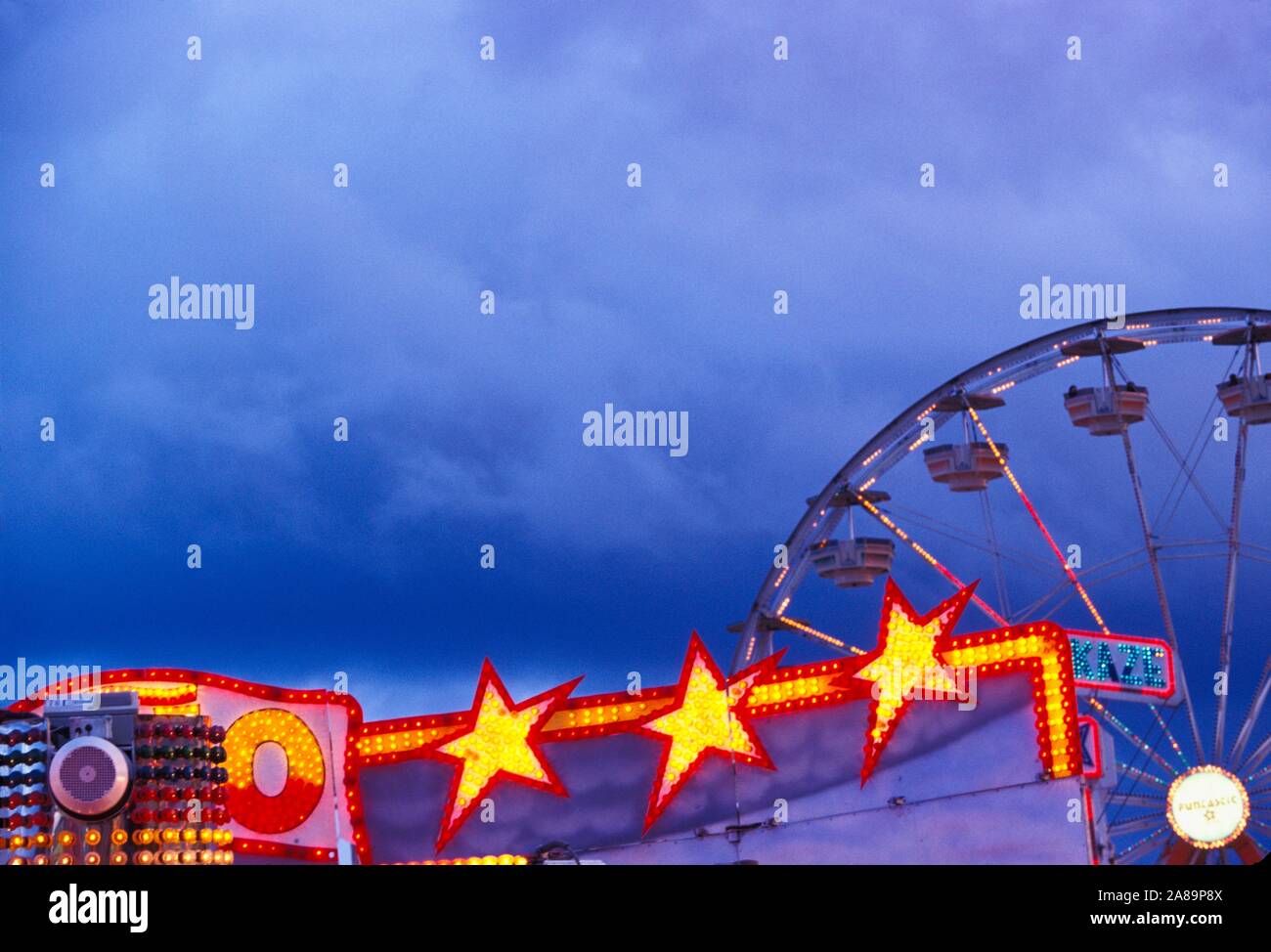 Whirling, illuminati al neon ride di carnevale al crepuscolo Foto Stock