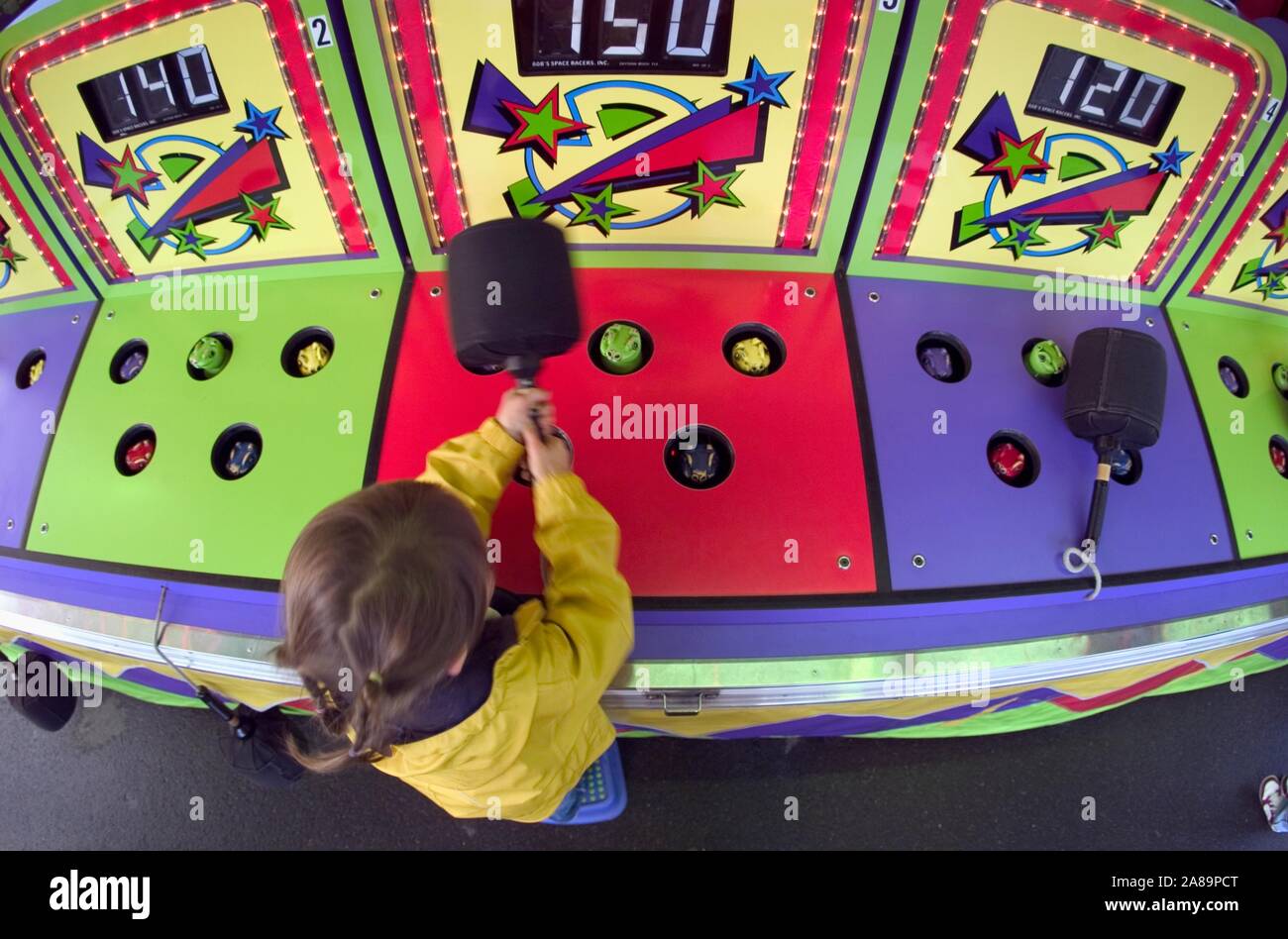 Vista aerea di una bambina gioca whack-a-mole a uno stato equo Foto Stock