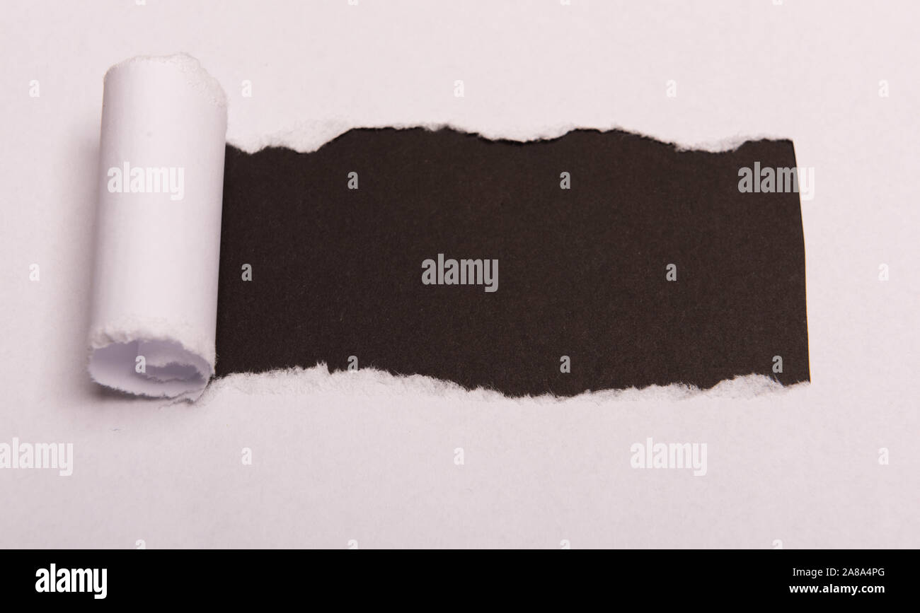 White carta strappata con spazio per il testo con sfondo nero. Messaggio nascosto. Segreto. Spazio di copia Foto Stock