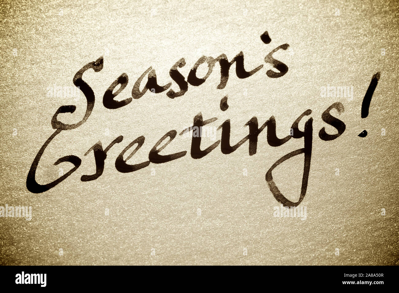 Manoscritti Auguri di Buone Feste! Carta vacanze messaggio in fresco calligrafia nero inchiostro su textured spumante carta oro Foto Stock