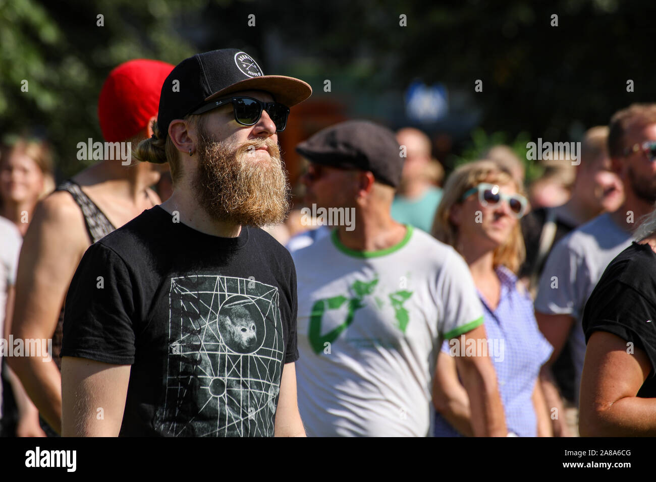 Giovane uomo con la barba e cappuccio di stoffa a guardare in concerto al Festival di Valli a Helsinki in Finlandia Foto Stock