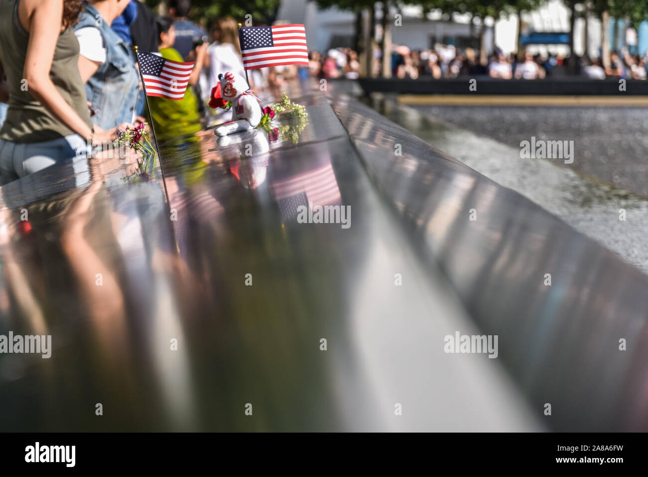 Fotografie concettuale della zona zero memorial. Bandierine americane, fiori e la gente intorno al memorial, dimostrare rispetto per le vittime. Manhatan, N Foto Stock