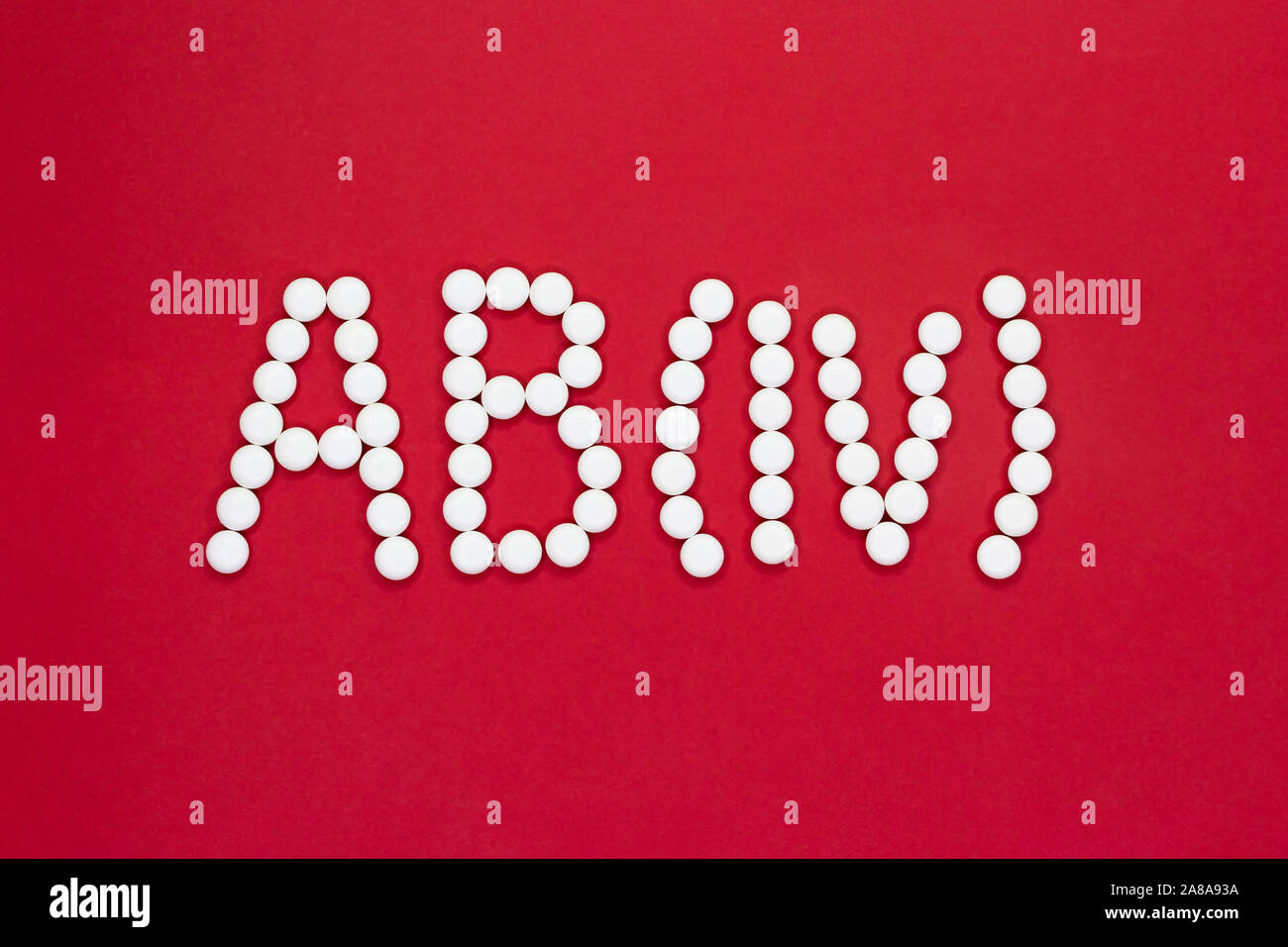 Quarto tipo di sangue. Simbolo del tipo di sangue da pillole bianche su sfondo rosso. Trattamento del tipo di sangue. Foto Stock