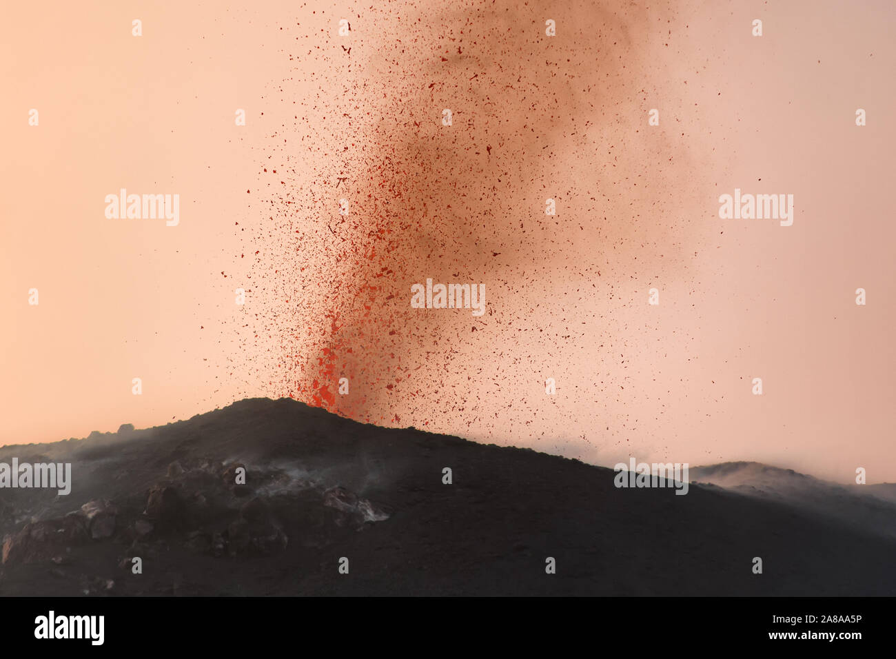 Eruzione esplosiva con proiezioni di magma e fumo arancione in uno dei tre crateri del principio attivo del vulcano di Stromboli, isole Eolie, Italia. Foto Stock