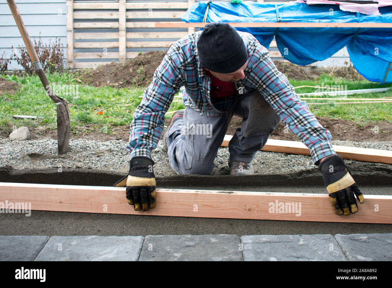 L'uomo Screeding sabbia per Patio lastricatore pietre, costruzione autentica, signor Foto Stock