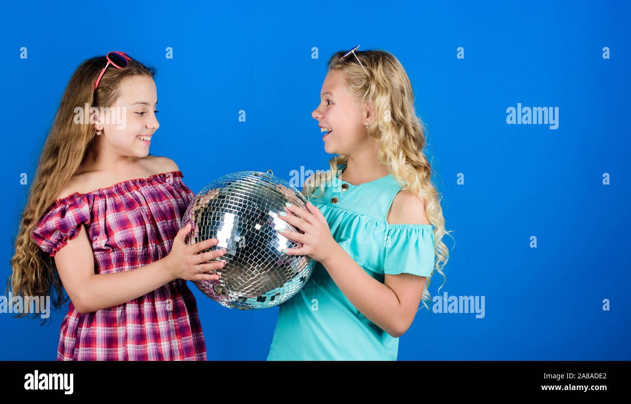 Iniziare a parte. Allegro kids tenere palla da discoteca. Discoteca danze. Musica retrò. Gli specchi riflettenti discoteca luci di atmosfera. Holiday celebrazione. Concetto di intrattenimento. Sorelle amici con palla da discoteca. Foto Stock