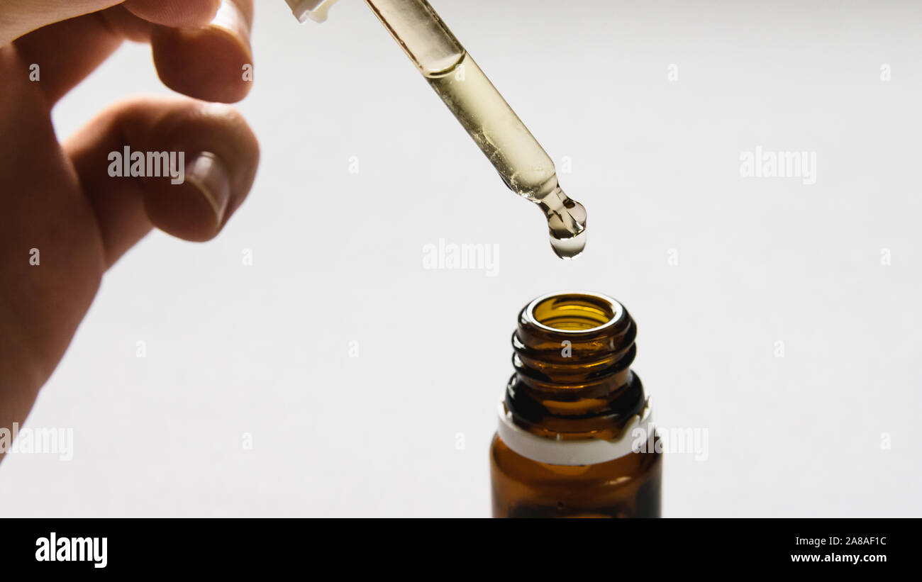 Prodotto cosmetico, bottiglia con acido ialuronico su uno sfondo bianco, close-up Foto Stock