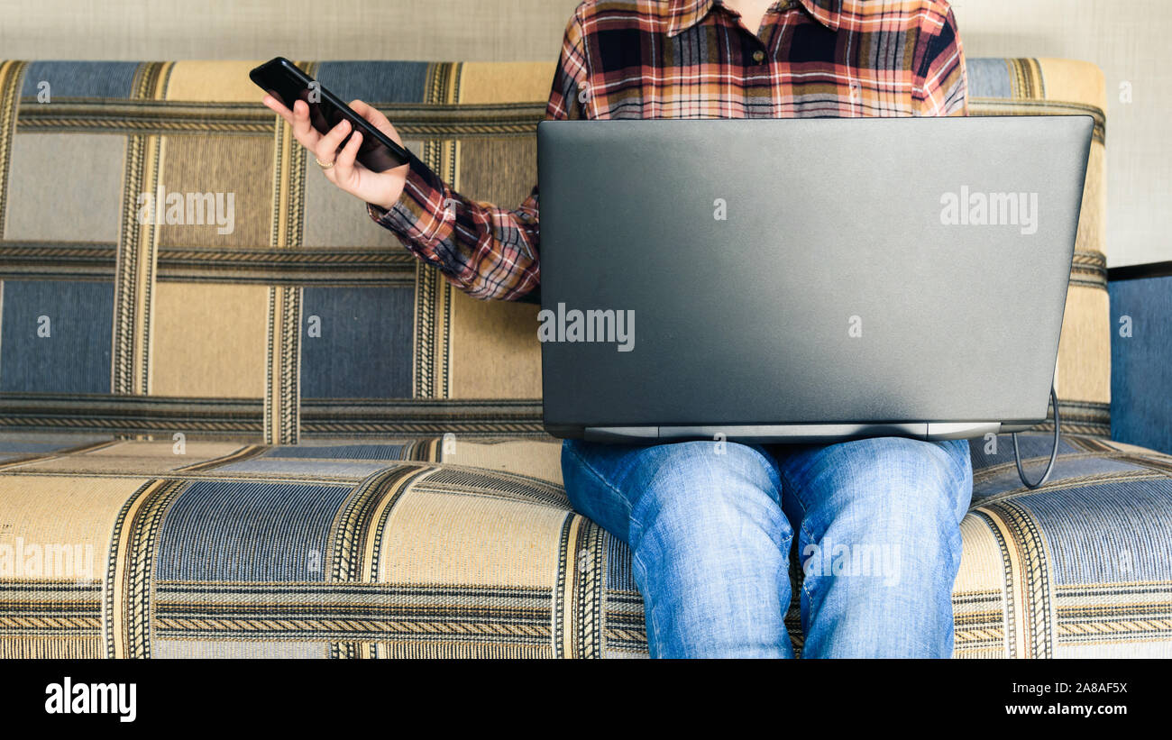 Ragazza detiene smartphone e laptop in mani Foto Stock