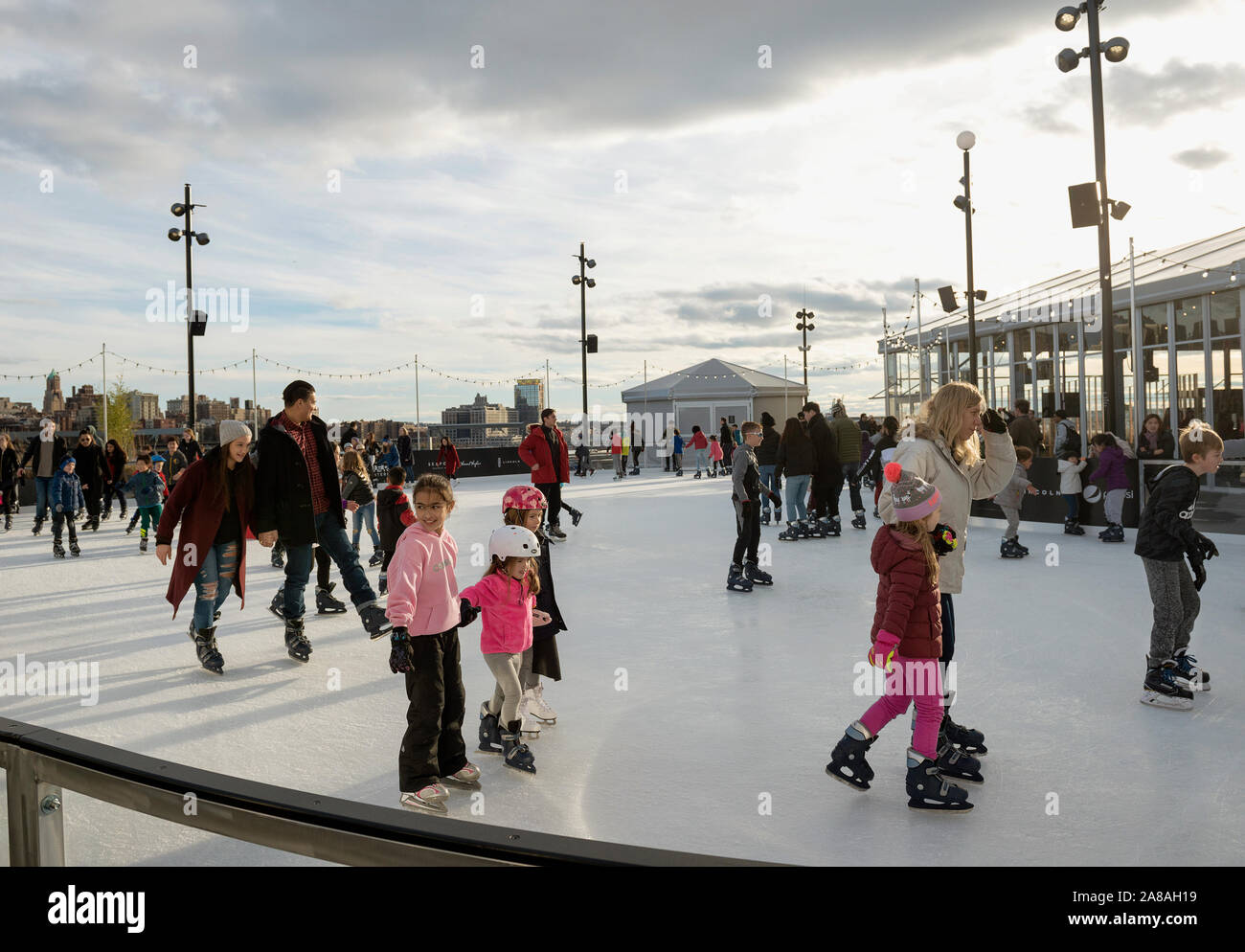 Pattinaggio sul ghiaccio sulla sommità del porto marittimo di Pier 17 nella città di New York. Foto Stock