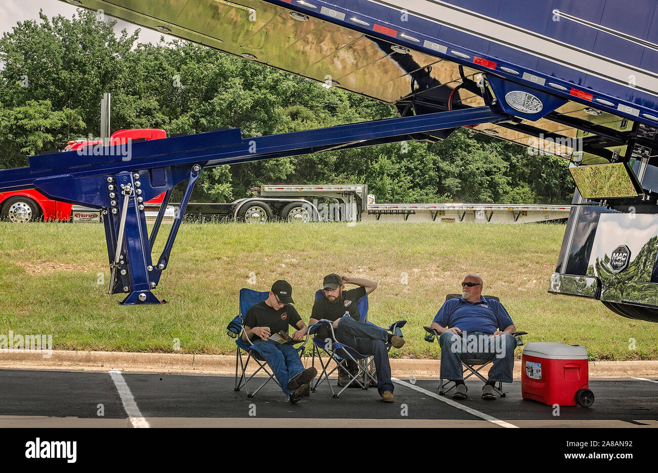 Gli uomini conservare al fresco sotto il carrello, un 2015 Peterbilt 389 con un 2017 MAC fine Dump, durante la trentaquattresima Shell annuale Rotella SuperRigs carrello show di Joplin. Foto Stock