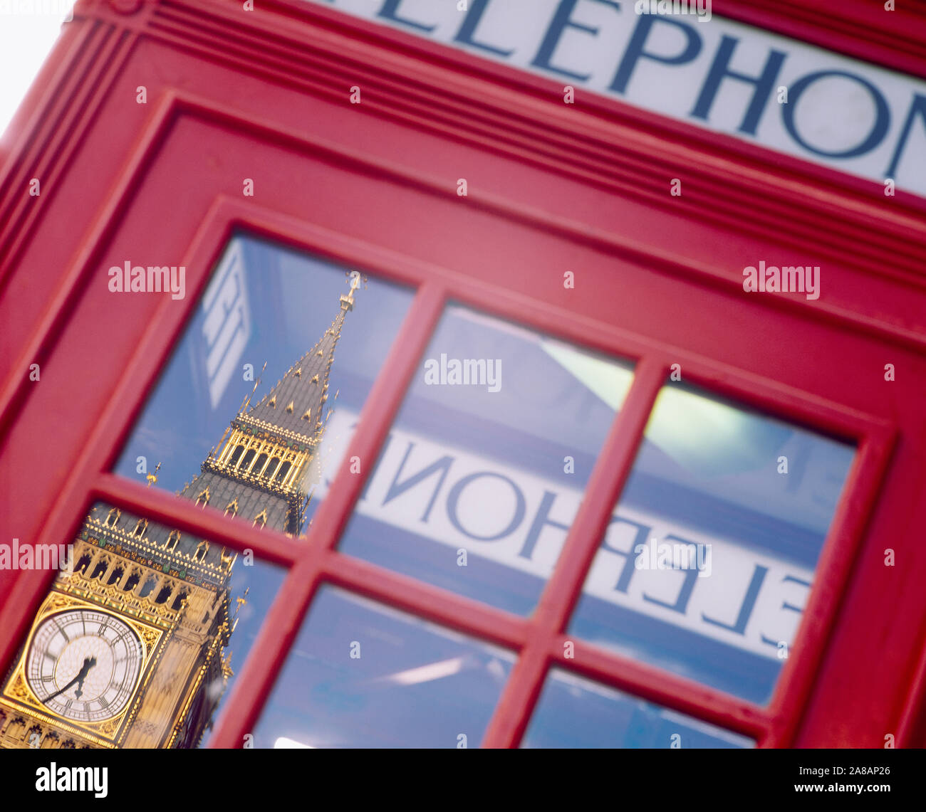 La riflessione di una torre orologio sul vetro di una cabina telefonica, Big Ben, Londra, Inghilterra Foto Stock