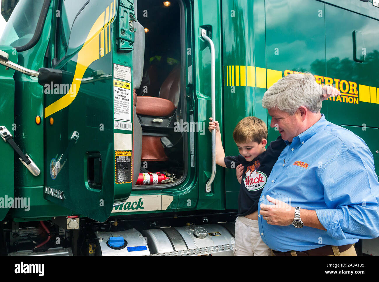 Un uomo aiuta a suo figlio salire su un Mack carrello di trasporto superiore, Sett. 30, 2015, in North Charleston, Carolina del Sud. Foto Stock