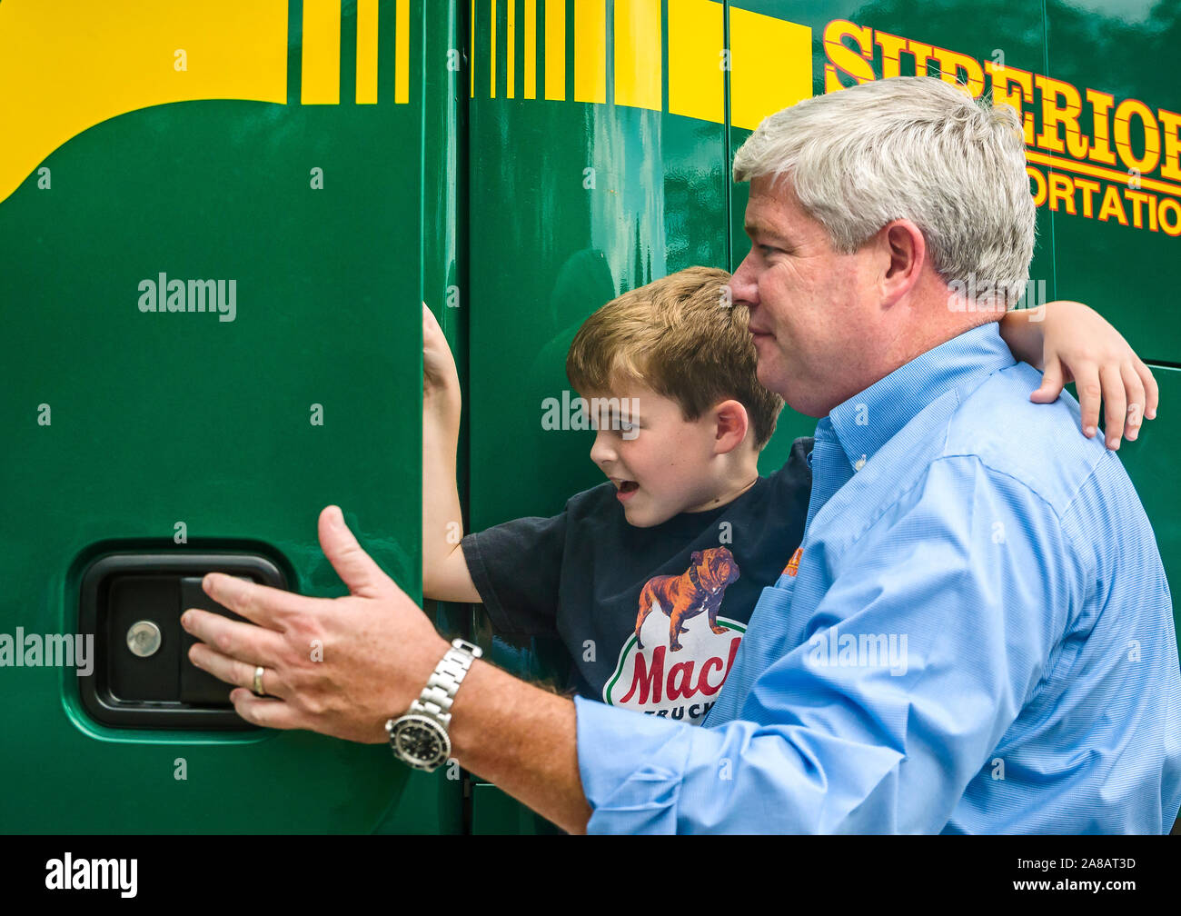 Un uomo aiuta a suo figlio salire su un Mack carrello di trasporto superiore, Sett. 30, 2015, in North Charleston, Carolina del Sud. Foto Stock