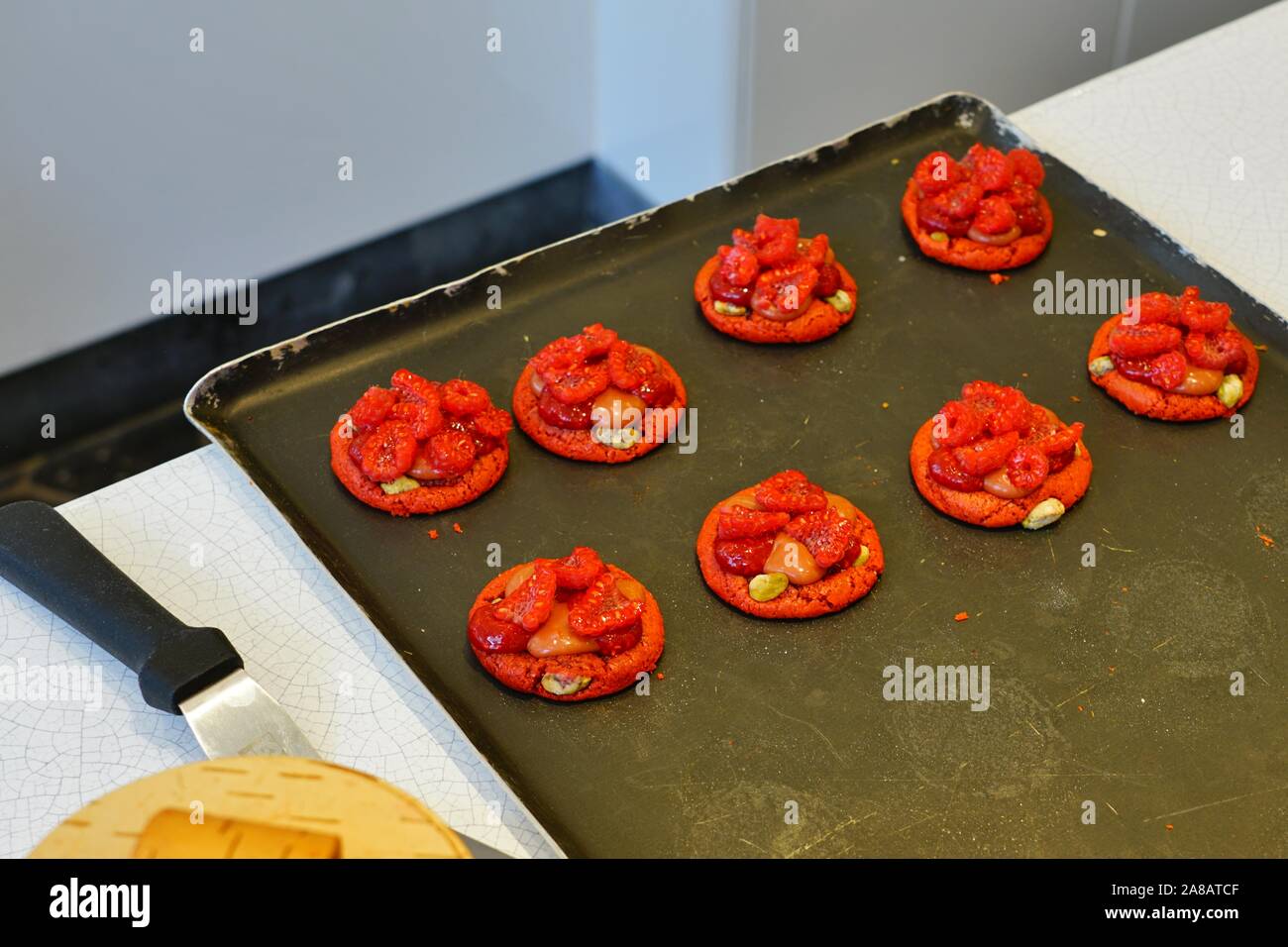 La cottura berry macaron crostate in una pasticceria francese Foto Stock