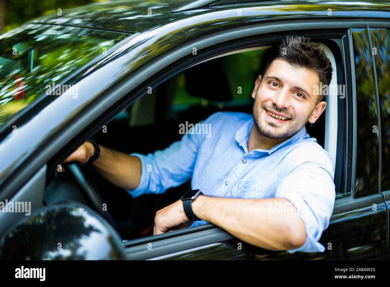 Ritratto di un bel ragazzo alla guida della sua auto Foto Stock