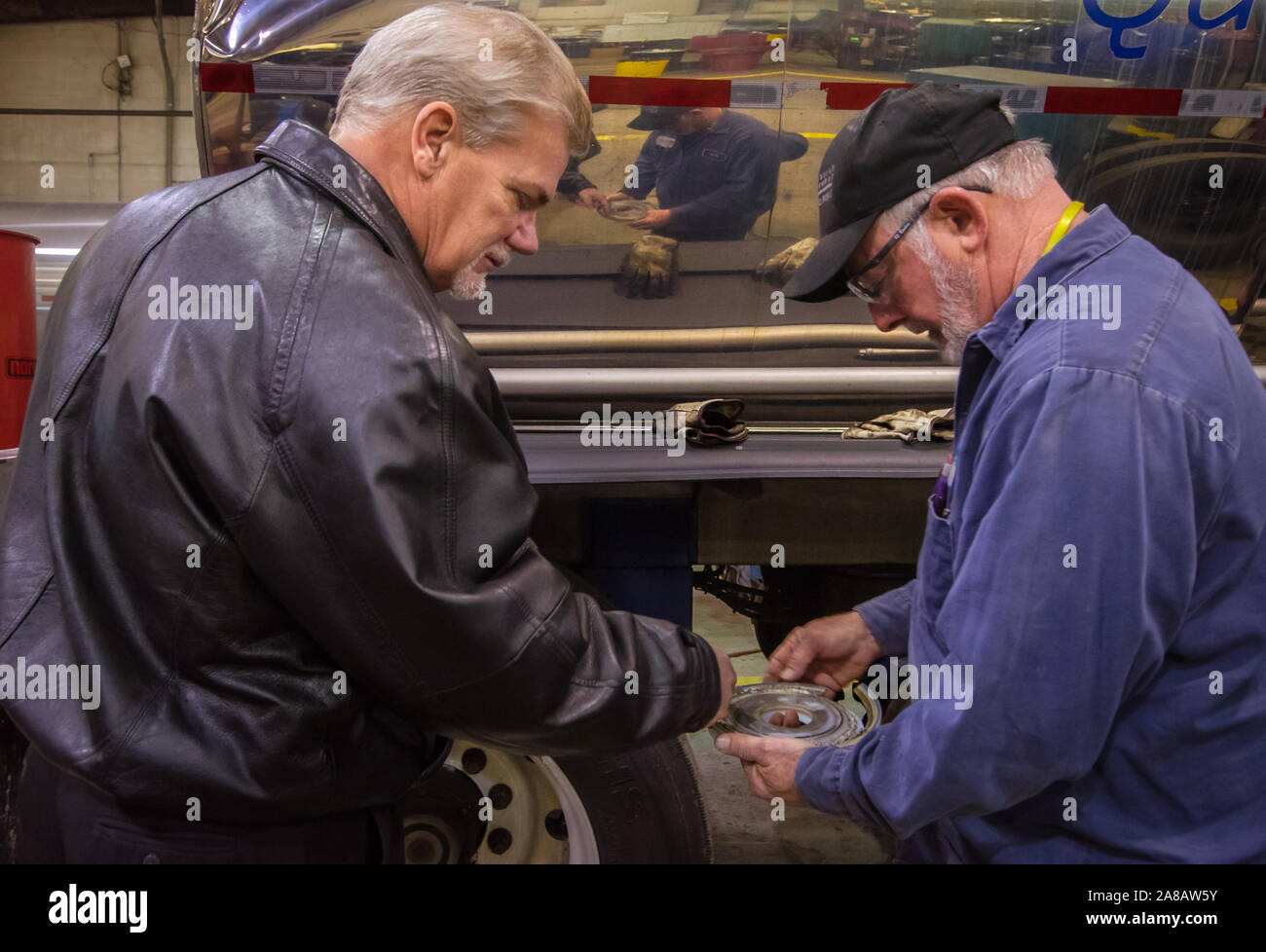 Larry Edwards, direttore di manutenzione per il trasporto autostradale chimico, colloqui con un meccanico su un lavoro di riparazione a Knoxville, Tennessee. Foto Stock