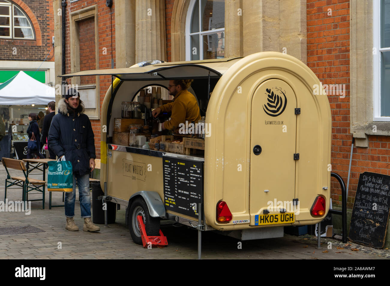 Un barista che serve caffè per un uomo da un artigiano coffee shop o caffè mobile stand Foto Stock