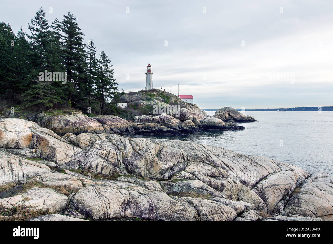 Bellissima vista sul punto Atkinson Faro Faro Park, West Vancouver, British Columbia, Canada. La foresta pluviale, pelliccia alberi sulla riva, roccia grezza Foto Stock