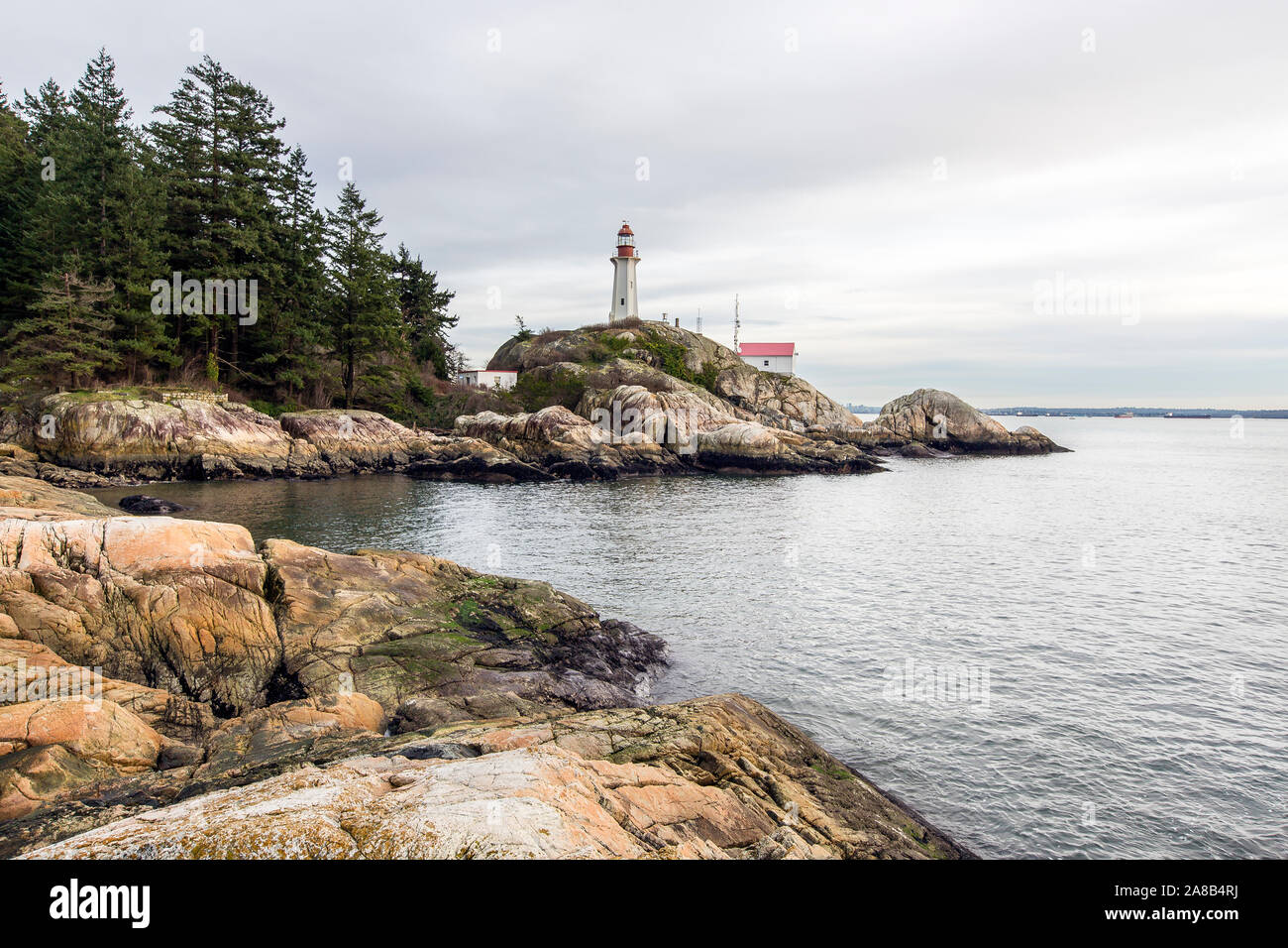 Bellissima vista sul punto Atkinson Faro Faro Park, West Vancouver, British Columbia, Canada. La foresta pluviale, pelliccia alberi sulla riva, roccia grezza Foto Stock