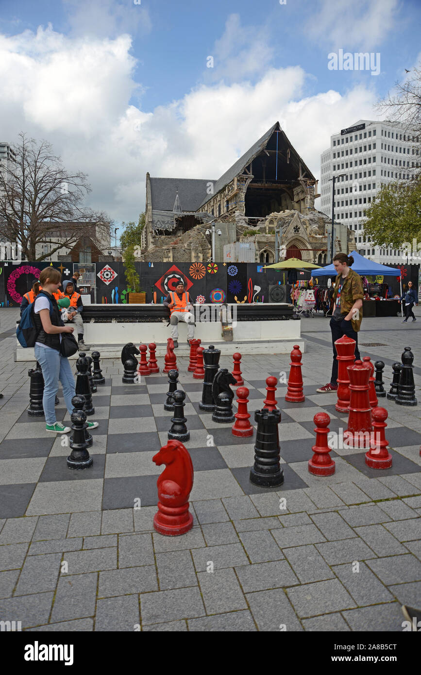 CHRISTCHURCH, Nuova Zelanda, 12 ottobre 2019: una giovane coppia di provare le loro competenze sulla scacchiera gigante in piazza Duomo Foto Stock