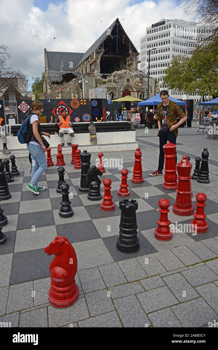 CHRISTCHURCH, Nuova Zelanda, 12 ottobre 2019: una giovane coppia di provare le loro competenze sulla scacchiera gigante in piazza Duomo Foto Stock