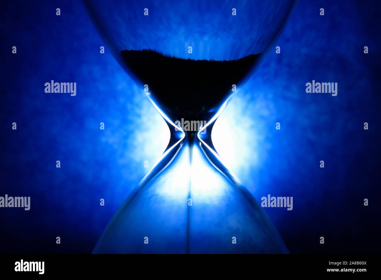 La clessidra di cristallo su sfondo blu, ispiratrice passare del tempo concetto Foto Stock