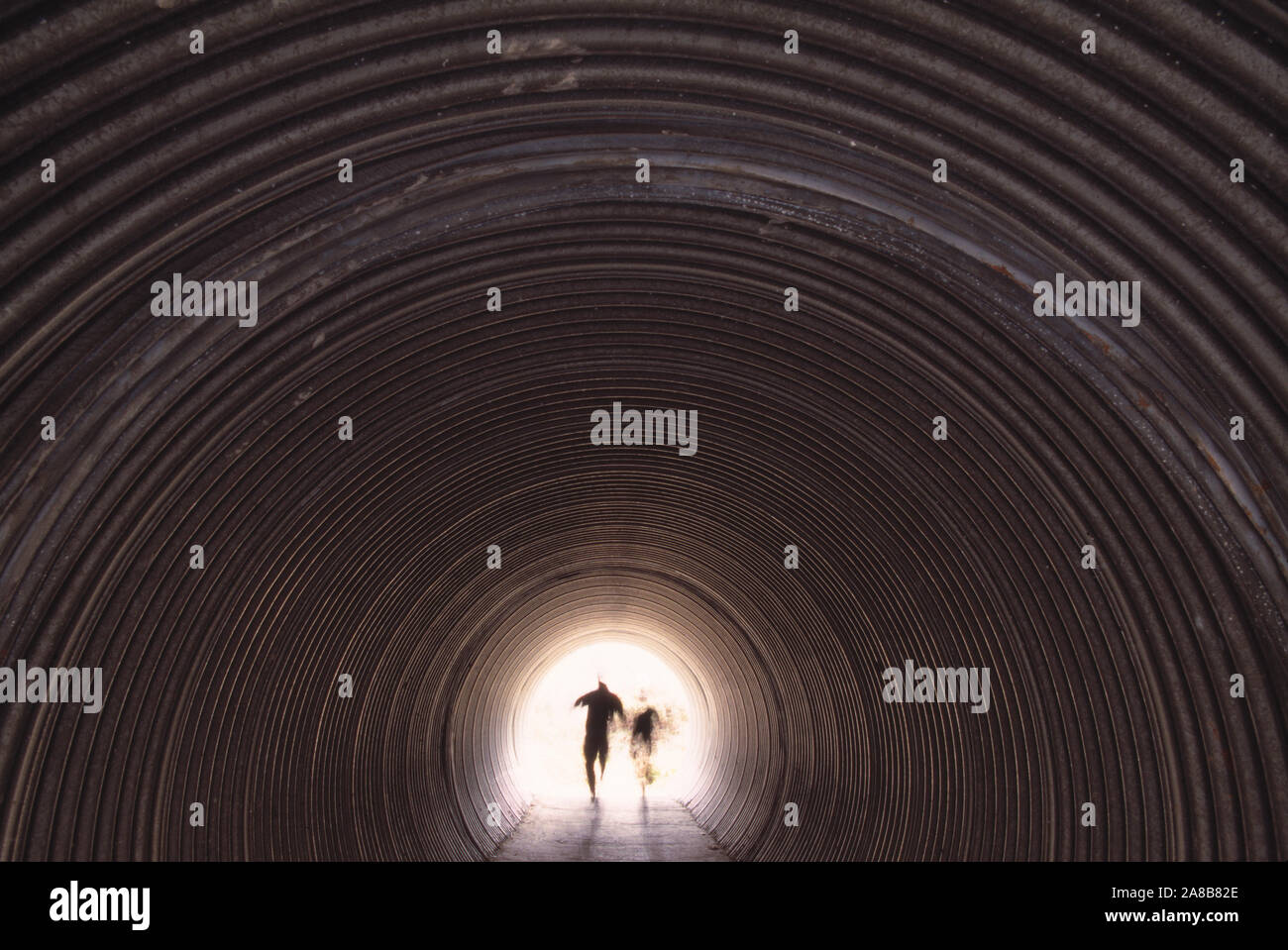 Due persone in esecuzione tramite il tunnel Foto Stock