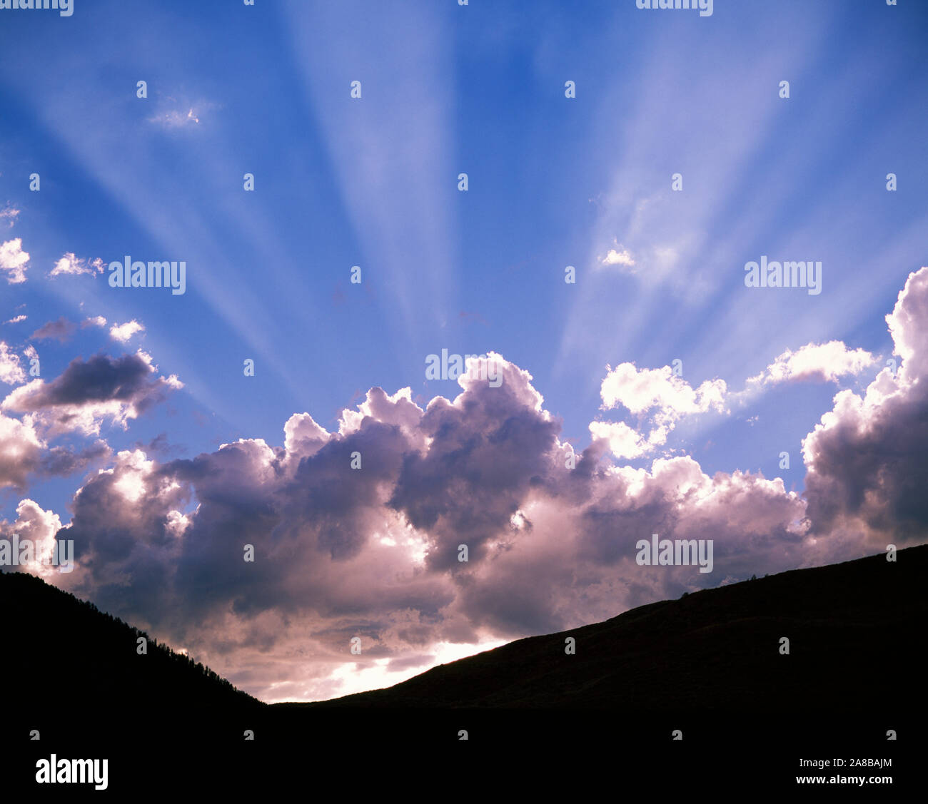 Sole che splende dietro le nuvole Foto Stock