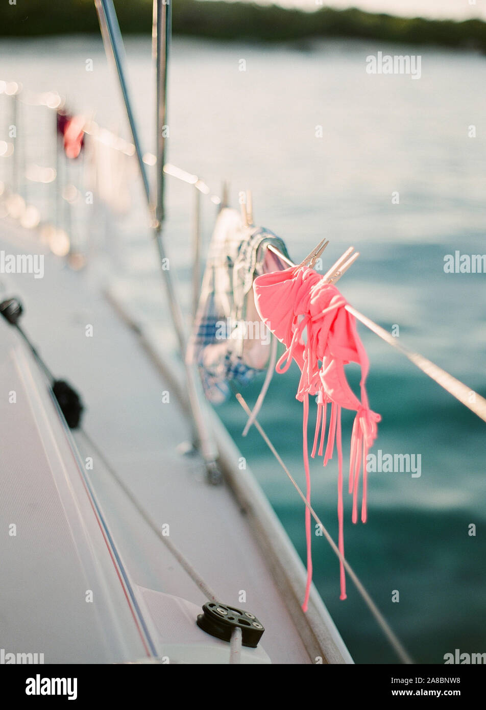Rosa bikini costume da bagno appeso sulla rampa di una barca a vela nei pressi di Virgin Gorda isola, Isole Vergini Britanniche, Isole dei Caraibi Foto Stock