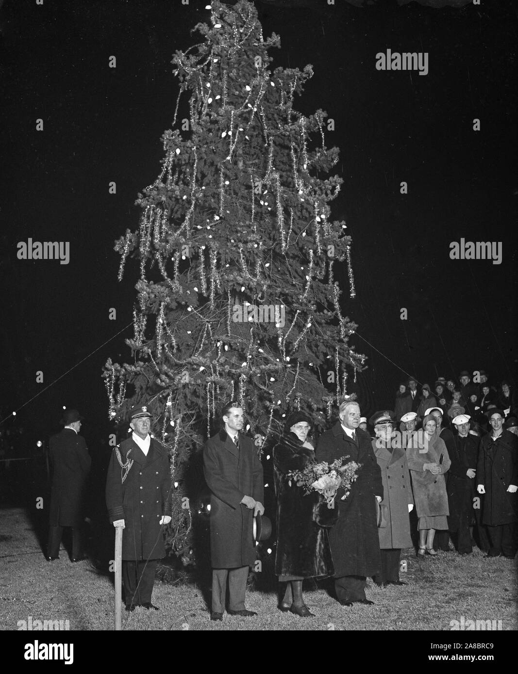 Presidente Hoover premuto il pulsante che illumina di Washington della comunità di albero di Natale appena prima che lui ha iniziato il suo breve 'Buon Natale' indirizzo radio per gli americani da costa a costa. 12/24/1930 Foto Stock