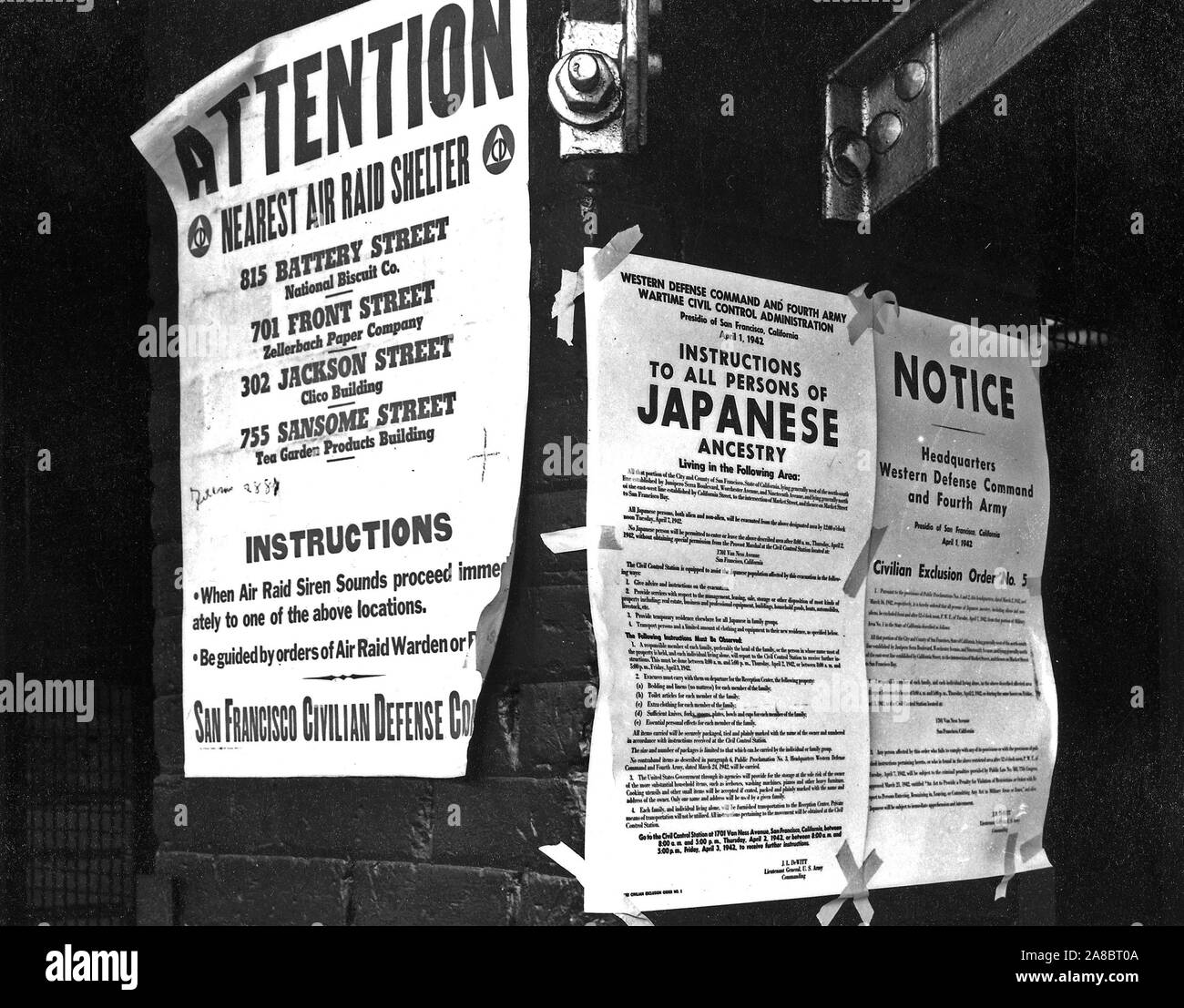 San Francisco, California. Su un muro di mattoni accanto a Air Raid Shelter poster, ordini di esclusione sono state pubblicate in un primo momento e strade anteriore dirigere il distacco delle persone di ascendenza giapponese dal primo San Francisco sezione per essere influenzata da evacuazione. Il provvedimento è stato emesso il 1 aprile 1942, dal tenente generale J.L. DeWitt e evacuazione diretta da questa sezione da mezzogiorno del 7 aprile 1942. (4/11/1942) Foto Stock