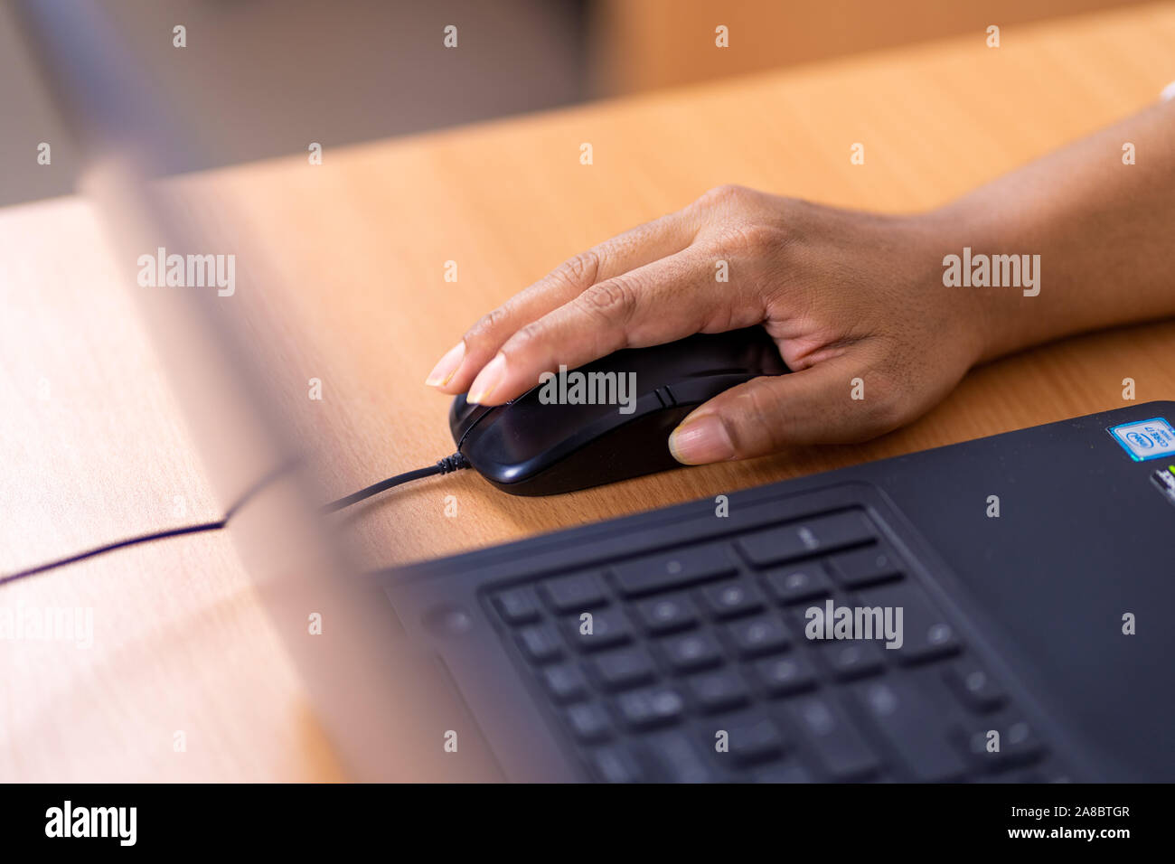 Femmina lato tenendo premuto il mouse del computer Foto Stock