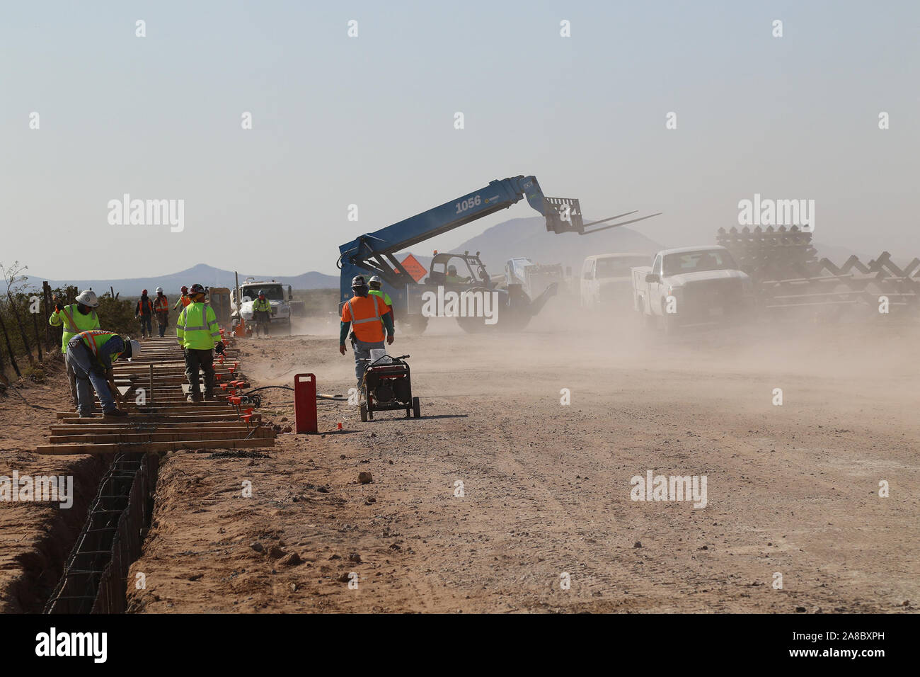 Un U.S. Esercito di ingegneri Task Force contraente barriera solleva un acciaio bollard pannello di barriera per calcestruzzo il posizionamento in una luce tempesta di polvere nei pressi di Colombo, N.M., Ottobre 29, 2019. USACE è fornire direzione e supervisione del Dipartimento della Difesa (DoD)-finanziato la costruzione della barriera di progetti di sistema lungo il confine sud-ovest. Questi progetti sono in corso di esecuzione da USACE, come diretto attraverso gli Stati Uniti Esercito dal Segretario della Difesa, in risposta al Dipartimento di Sicurezza della richiesta di assistenza per proteggere gli Stati Uniti frontiera meridionale bloccando i trafficanti di droga nei corridoi in Foto Stock