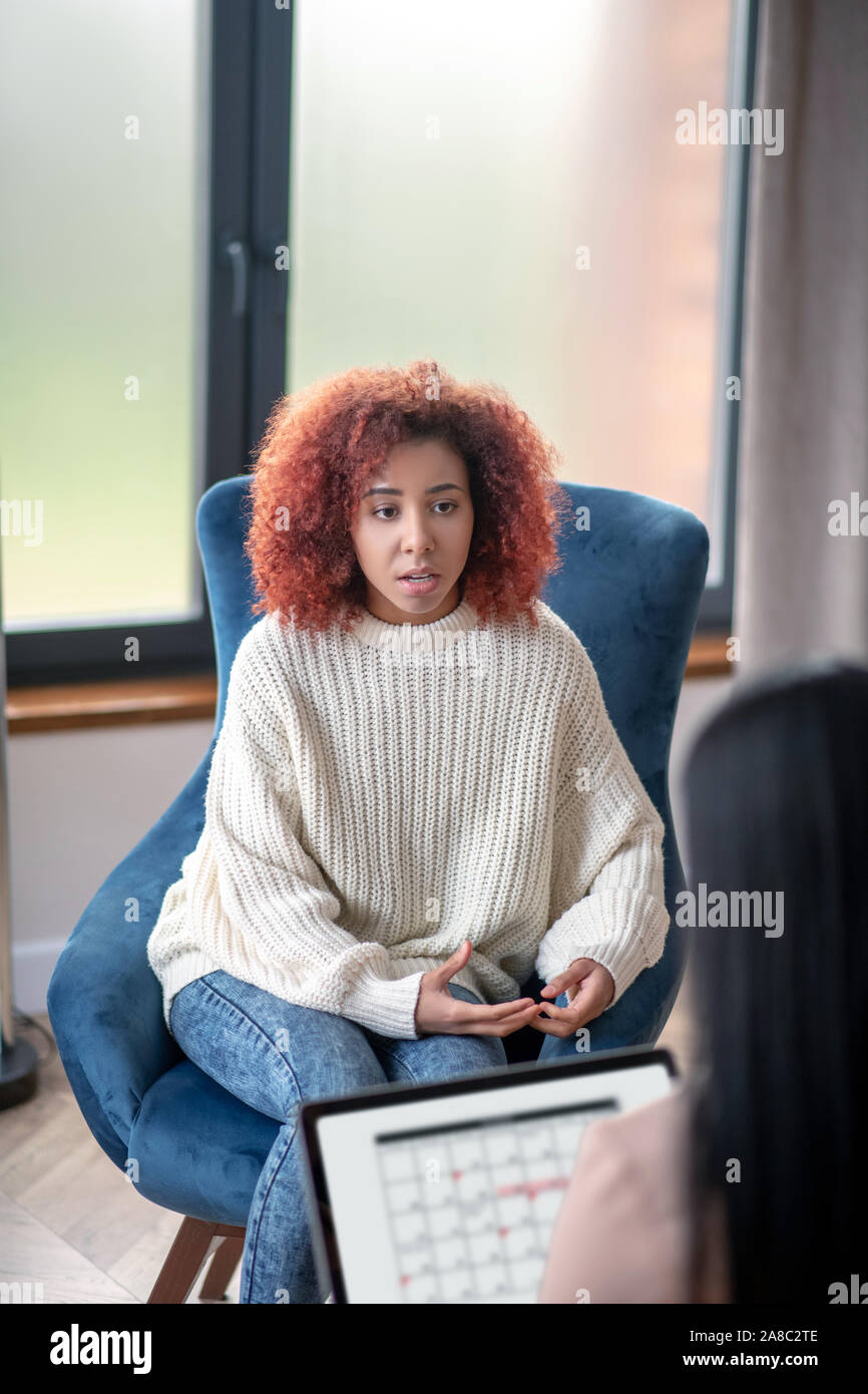Curly donna condividere i suoi pensieri con psicanalista Foto Stock