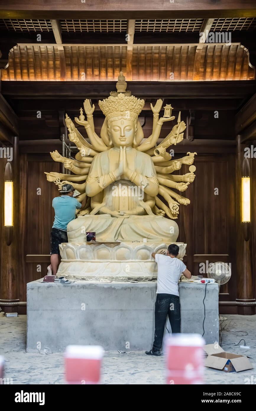 Chengdu, Cina - Luglio 2019 : i lavoratori di sesso maschile la creazione e il ripristino di grandi sculture di multi consegnato il dio Shiva nel cortile di Wenshu buddista M Foto Stock