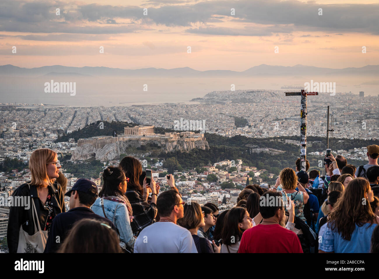 Athens, Grecia - 16 Maggio 2019: il turista a godere il tramonto sulla città di Atene, l'Acropoli e il Partenone dal Monte Lycabettus. Foto Stock