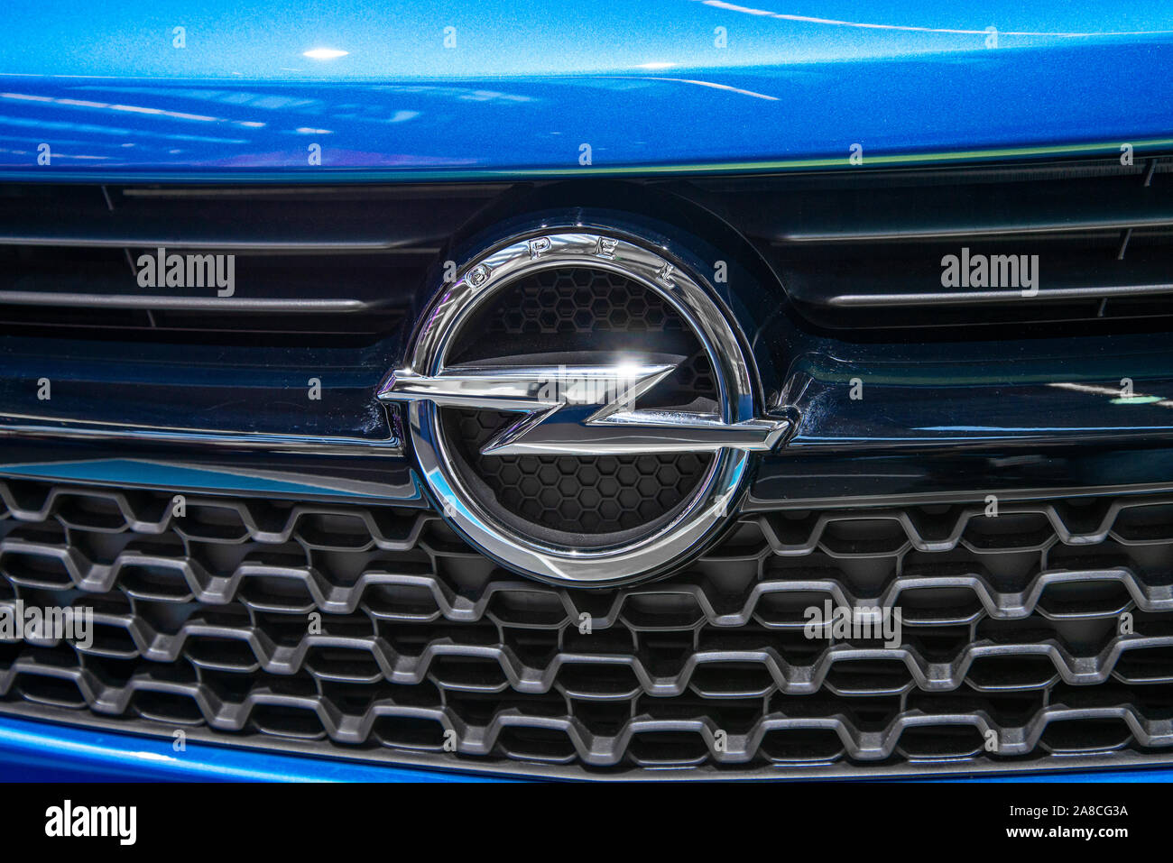 Il logo di Opel su un auto blu di questo marchio Foto Stock