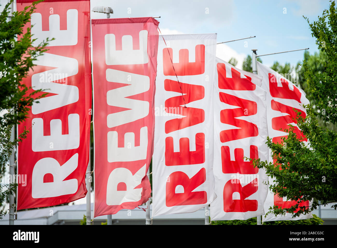 Le bandiere con il logo dei supermercati della drogheria Rewe Foto Stock