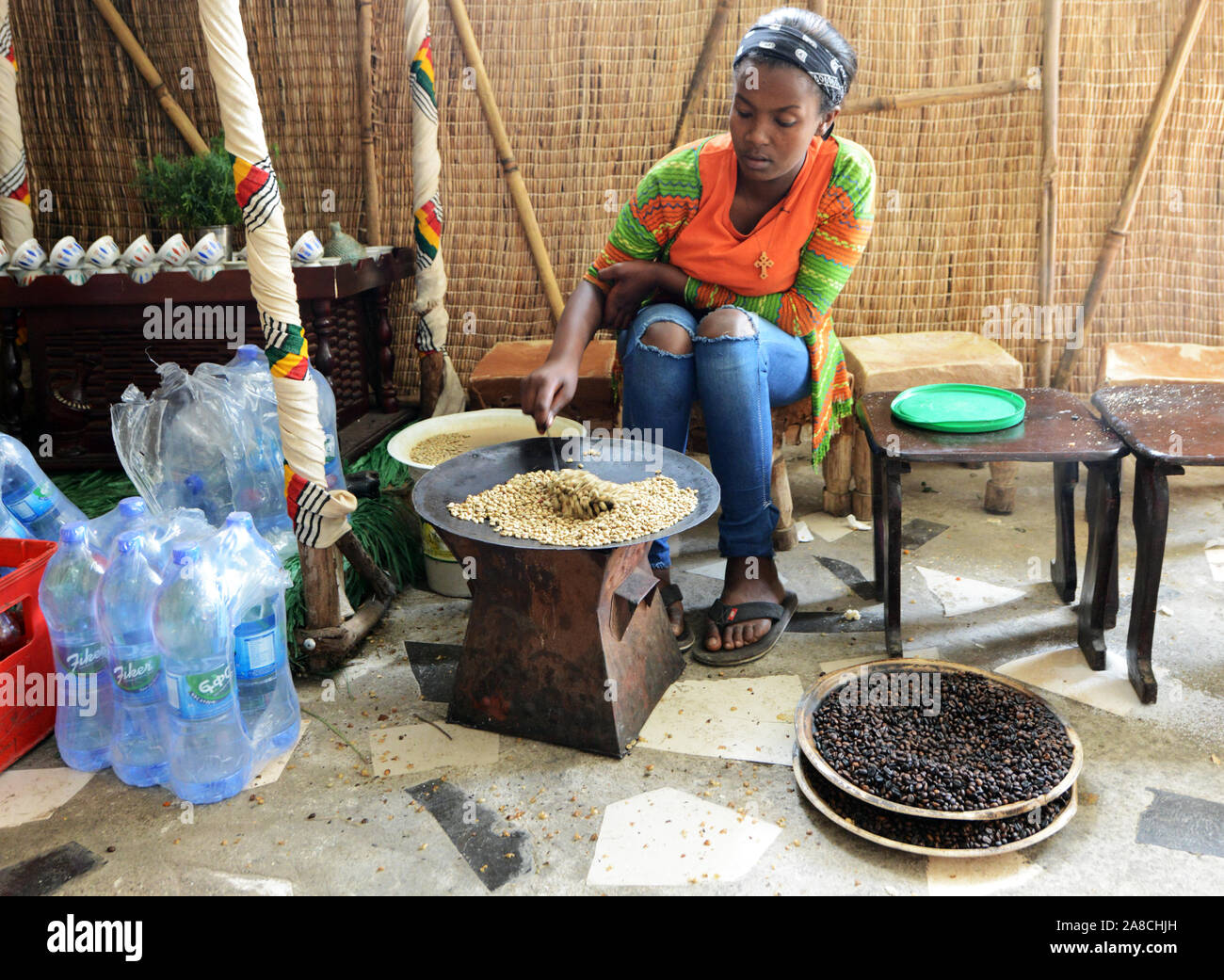 Una giovane donna etiope la tostatura i chicchi di caffè in preparazione del tradizionale caffè etiope. Foto Stock