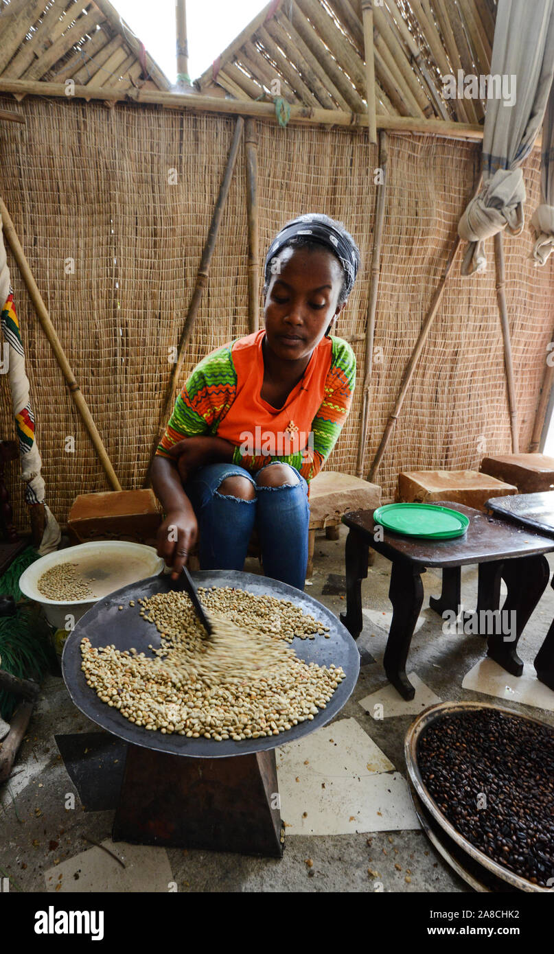 Una giovane donna etiope la tostatura i chicchi di caffè in preparazione del tradizionale caffè etiope. Foto Stock