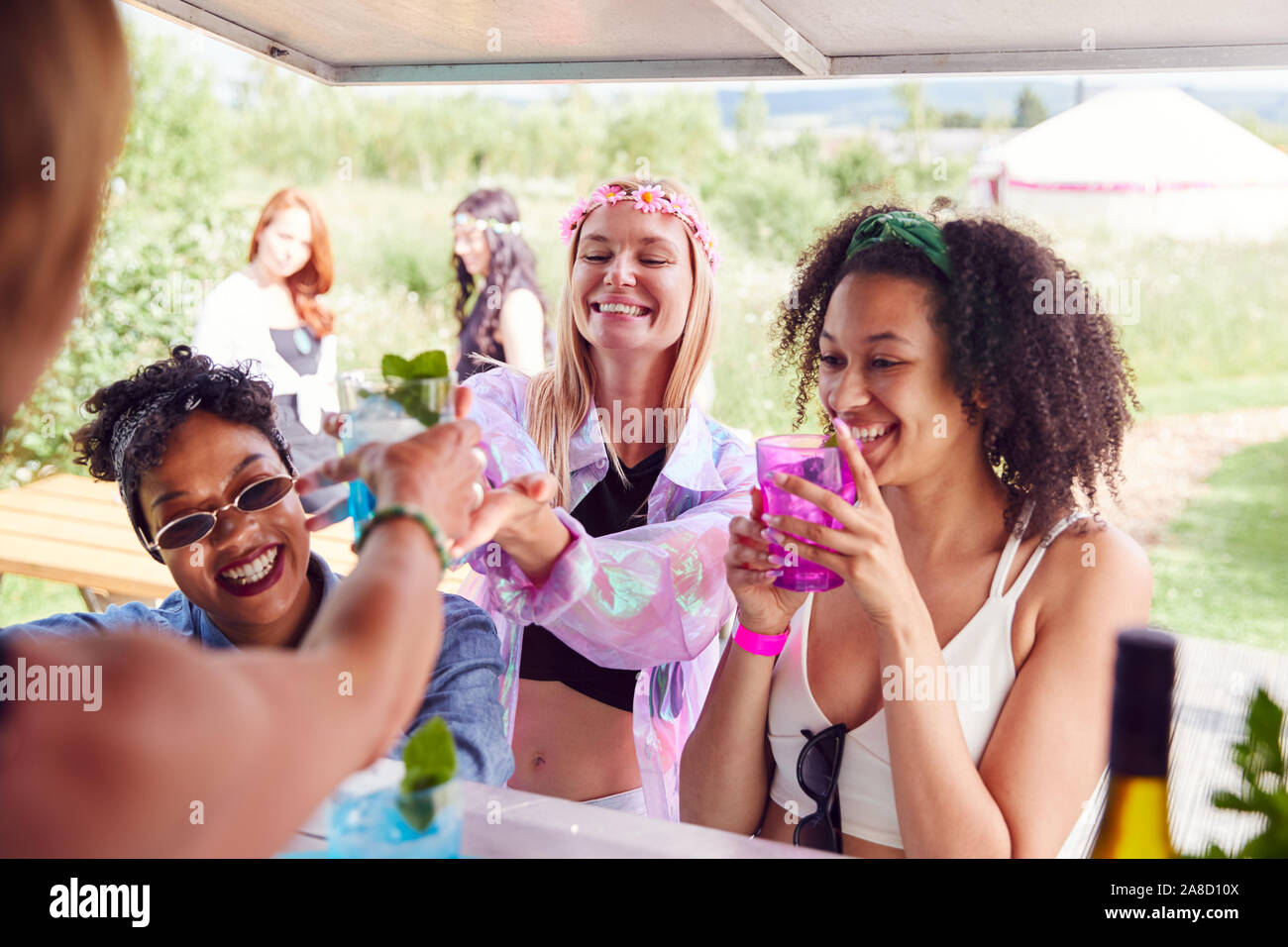 Amici di sesso femminile acquistare drinks dal bar presso il Festival di musica Foto Stock