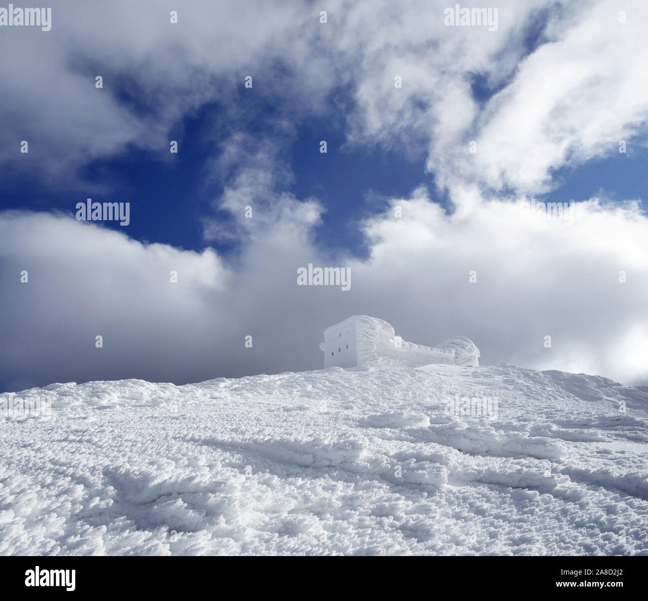 Paesaggio invernale con un osservatorio sulla cima di una montagna. Bella brina e cumuli di neve. Le difficili condizioni atmosferiche Foto Stock