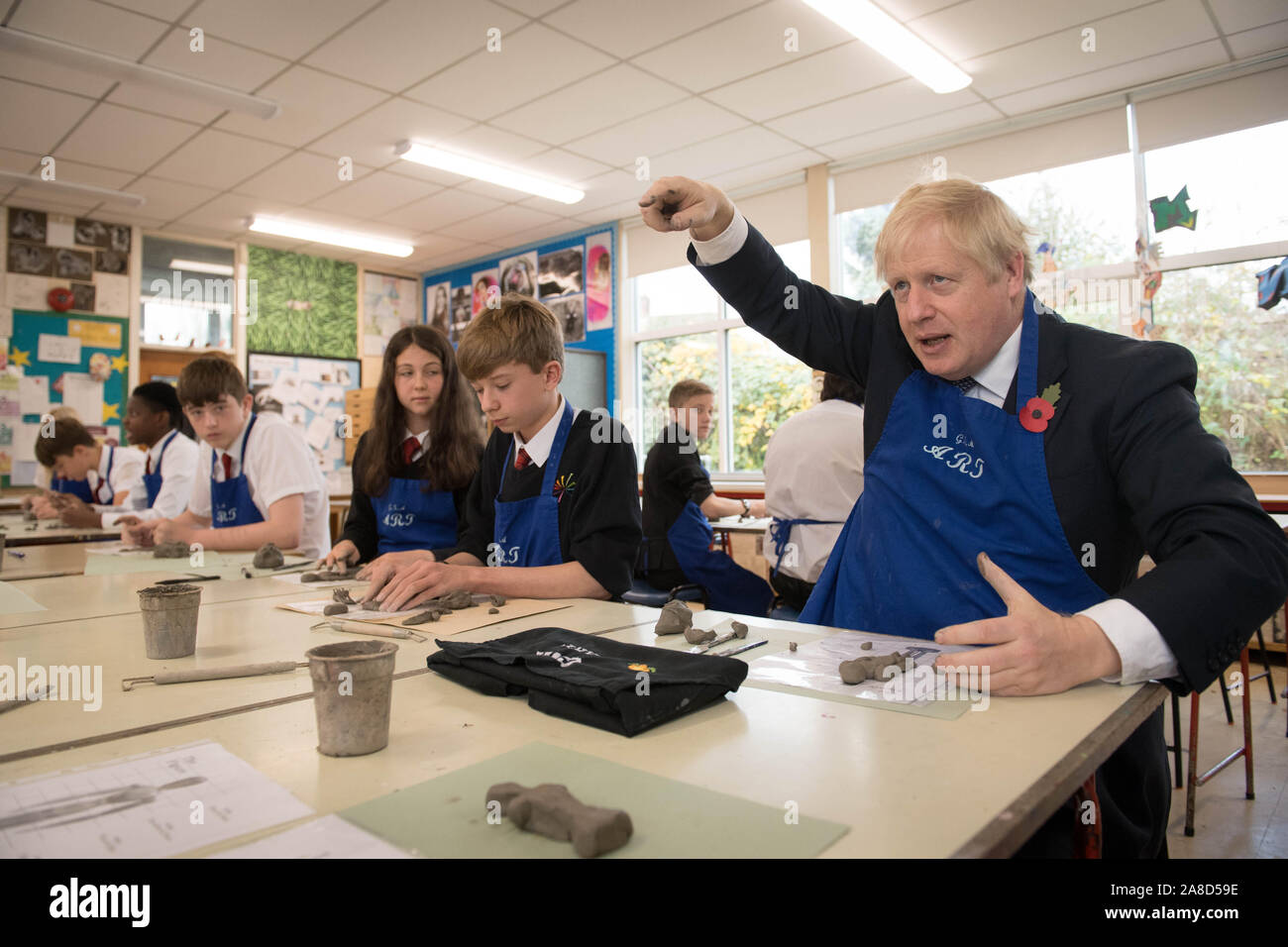 Il primo ministro Boris Johnson cerca la sua mano a rendere un Antony Gormley ispirato creta figura durante una classe di arti mentre visita il George Spencer Academy di Nottingham, durante la campagna elettorale del sentiero intorno al paese. Foto Stock