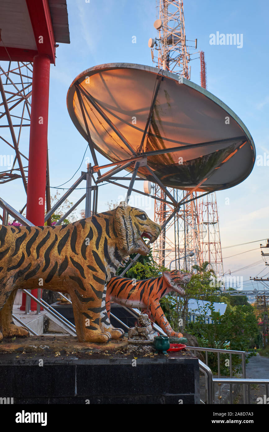 Una stazione TV satellite dish & Torre per antenna su Khao Toh Sae (Monkey Hill), la città di Phuket, Thailandia, tigri segnando l'ingresso di un tempio cinese Foto Stock