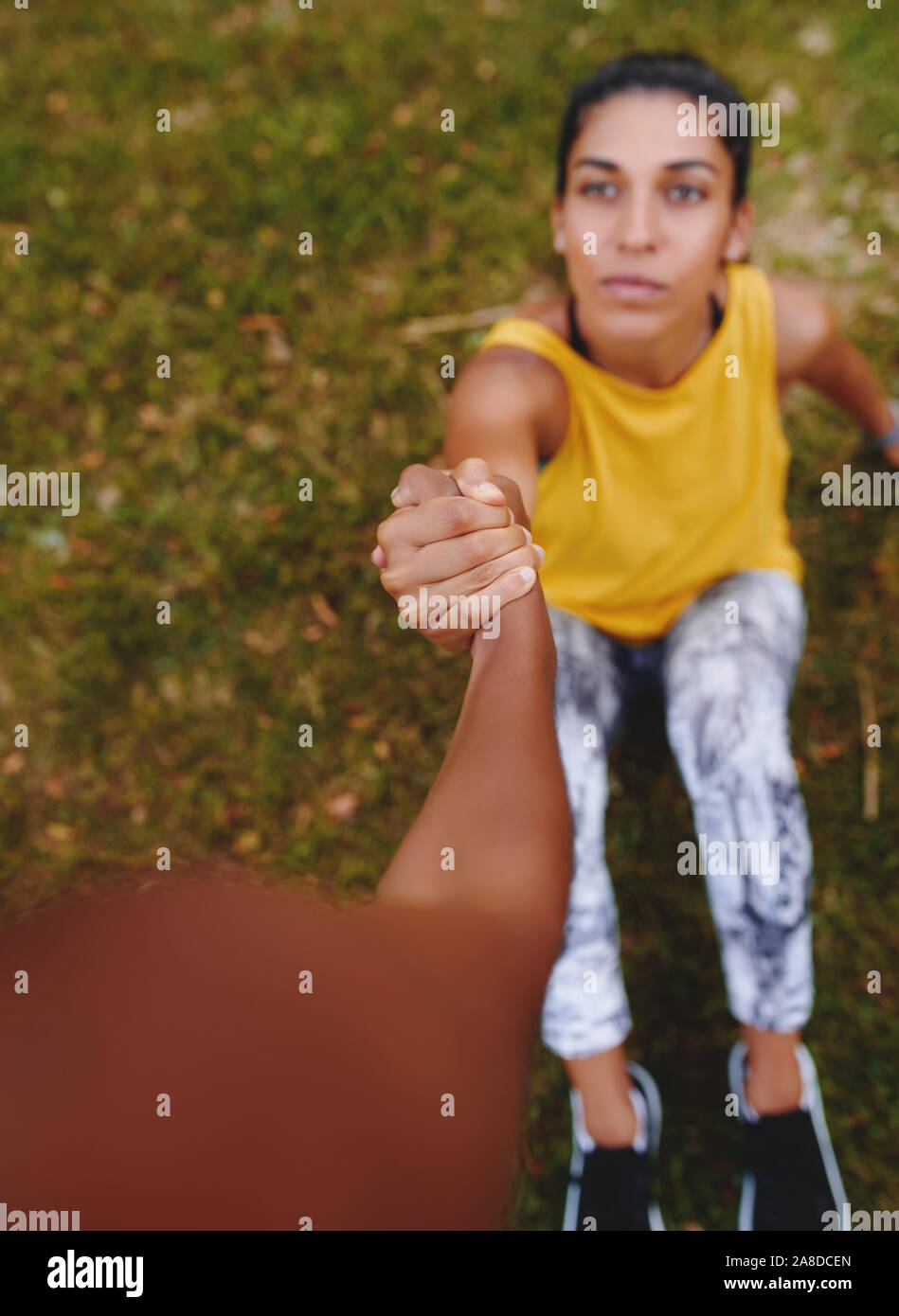 Due giovani atlete tenendo reciprocamente le mani che mostra il supporto e rapporto amichevole durante gli allenamenti - amico di dare una mano a un Foto Stock