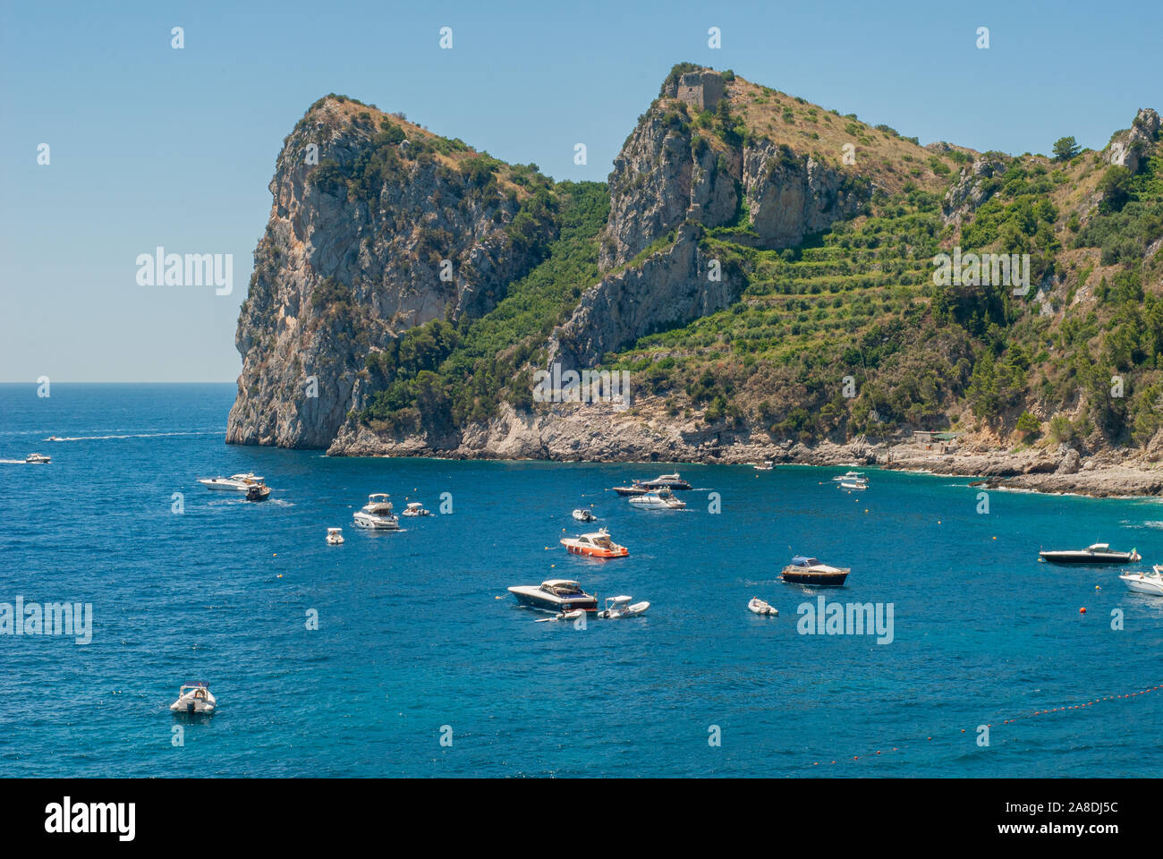 Tre lacci della Baia di Ieranto, con la Torre di Montalto sul vertice e barche in mare, preso dalla spiaggia di Nerano, vicino a Sorrento Foto Stock
