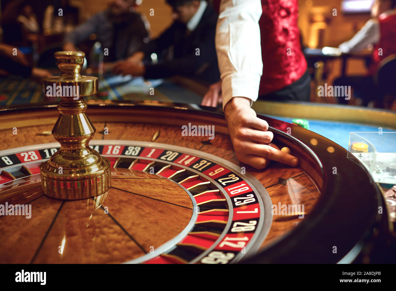 Mano di un croupier su una roulette whell in un casinò. Foto Stock