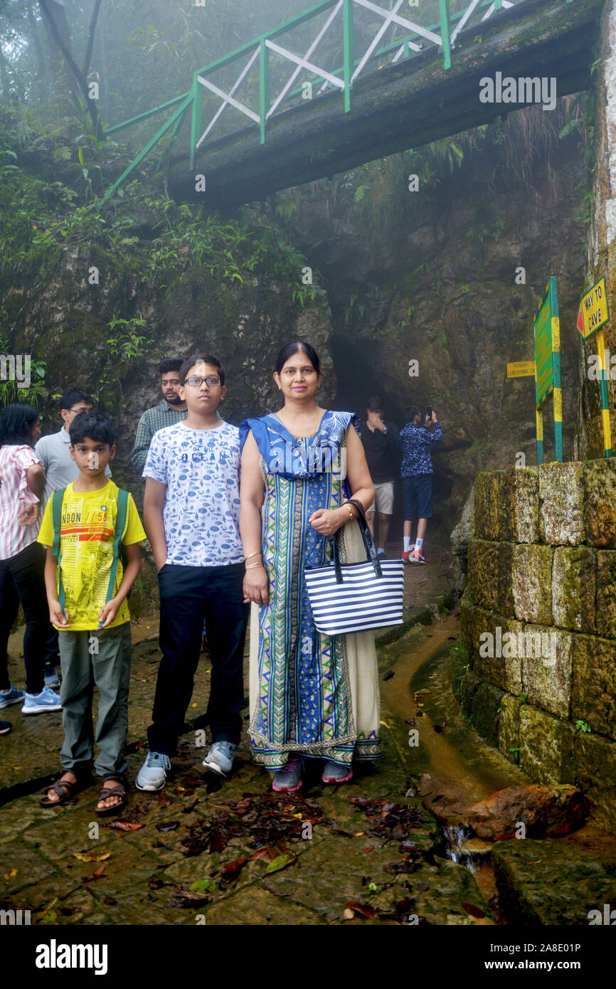 Una famiglia indiana composta da madre e figlia figli in posa di fronte alle grotte di Cherrapunjee progetto ecologico conoscere noto come altopiano Sohra Foto Stock